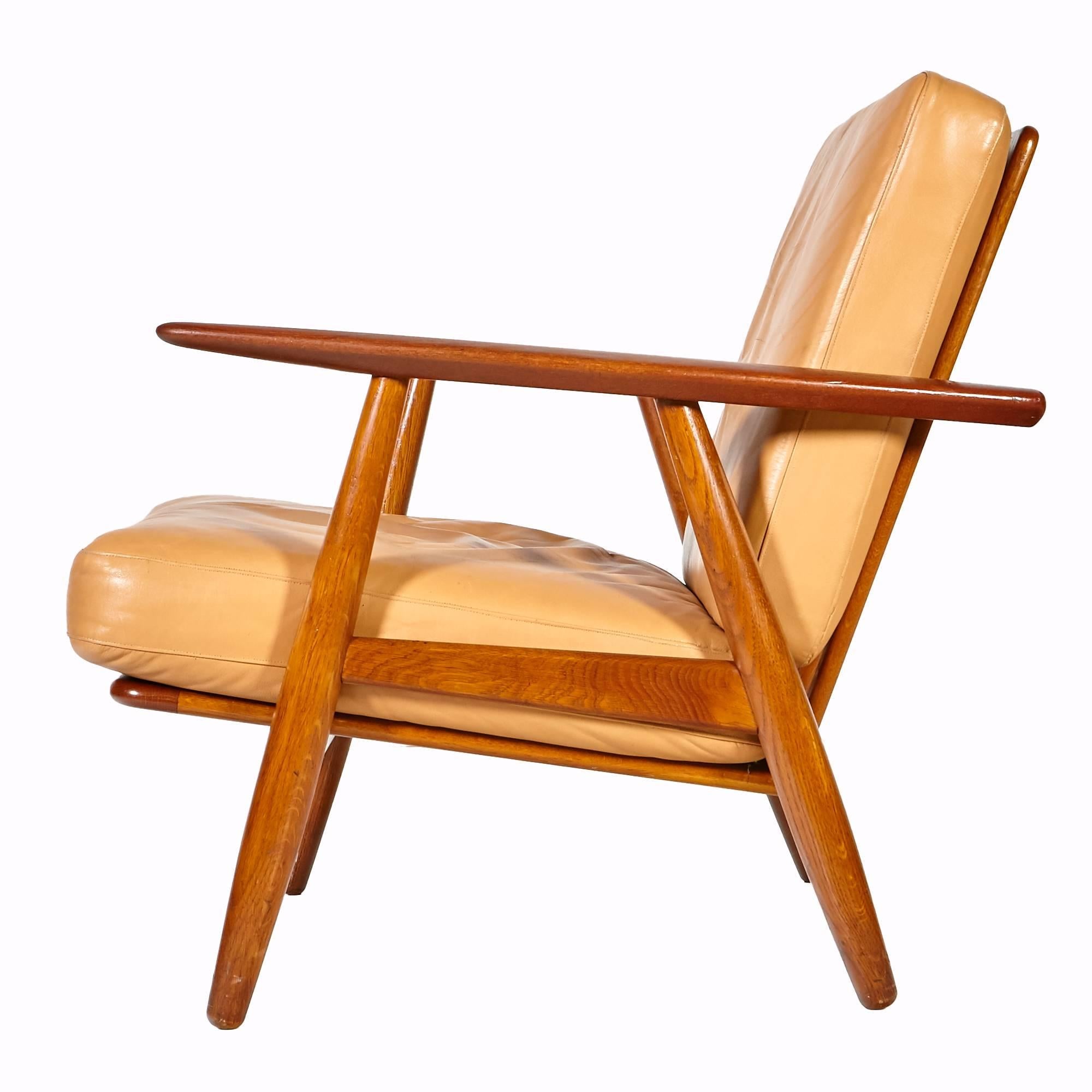 1955 Danish teak GE-240 lounge chair designed by Hans J. Wegner and manufactured by Getama of Denmark. Comes with the original butterscotch leather upholstery. Marked on the underside. Minor wear to the leather from use.