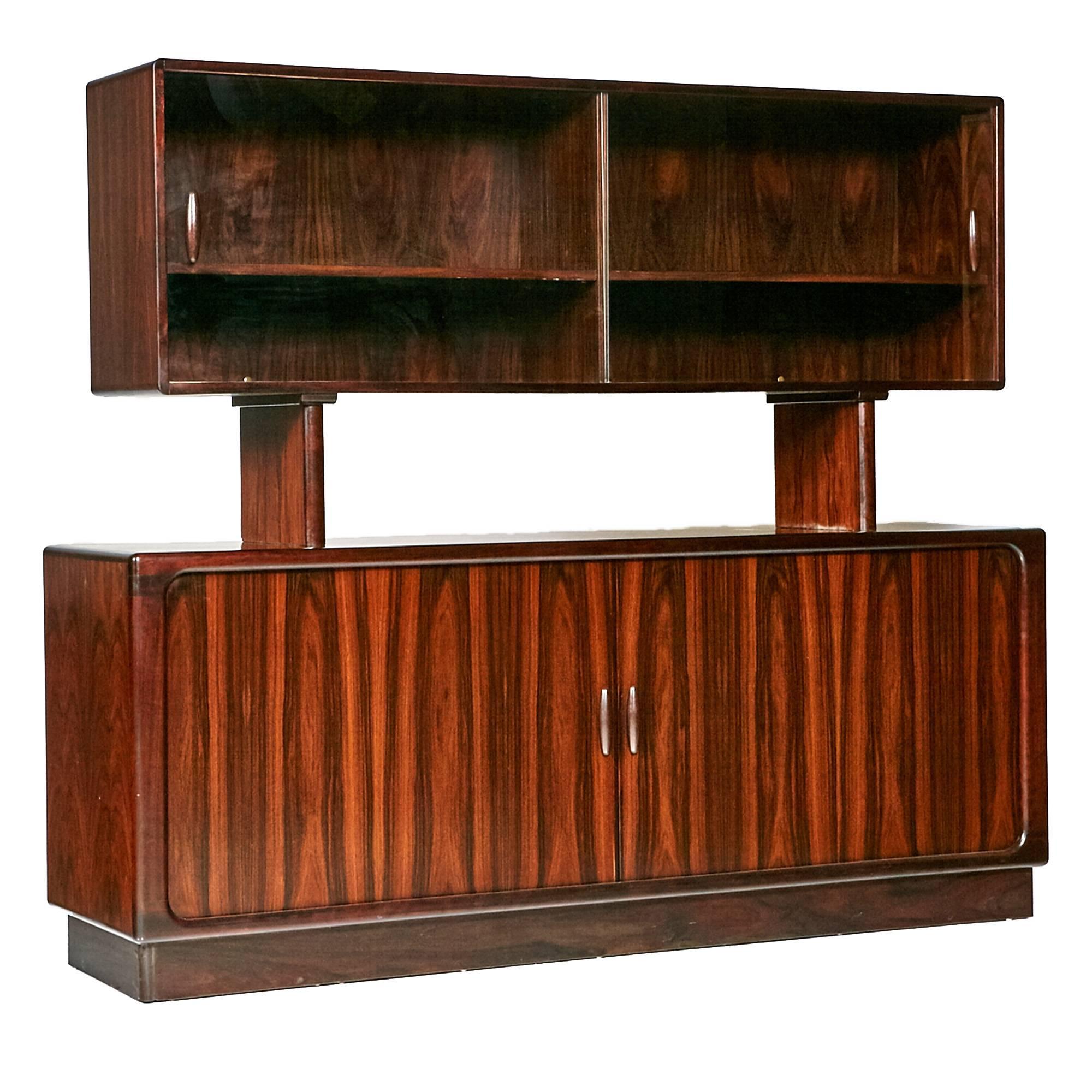 1960s Danish rosewood two-piece credenza with tambour doors with sliding glass doors on top. The base has five drawers for storage and the handles are sculpted rosewood. The top and bottom are not attached. Marked: Dyrlund.