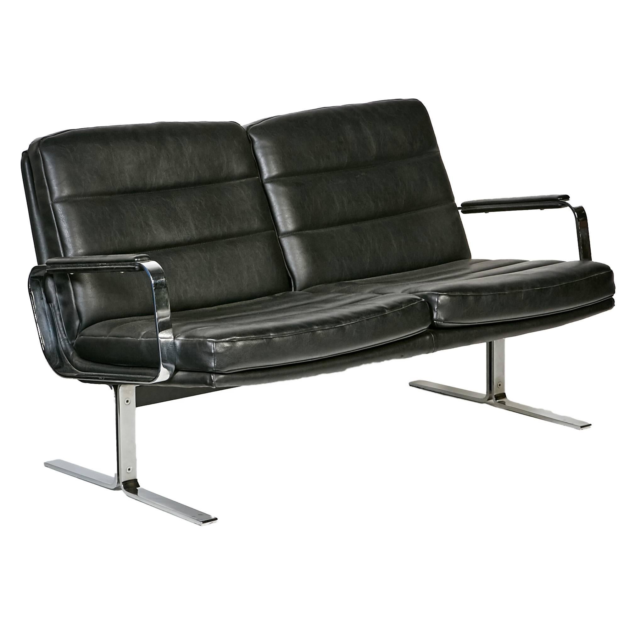 1970s black leather and flat-bar chrome airport-style living room/office set designed by Bernd Münzebrock for Knoll. The set includes a two-seat sofa, lounge chair and rosewood top coffee table. The sofa is 49.5" L x 24" W x 28.5" H,
