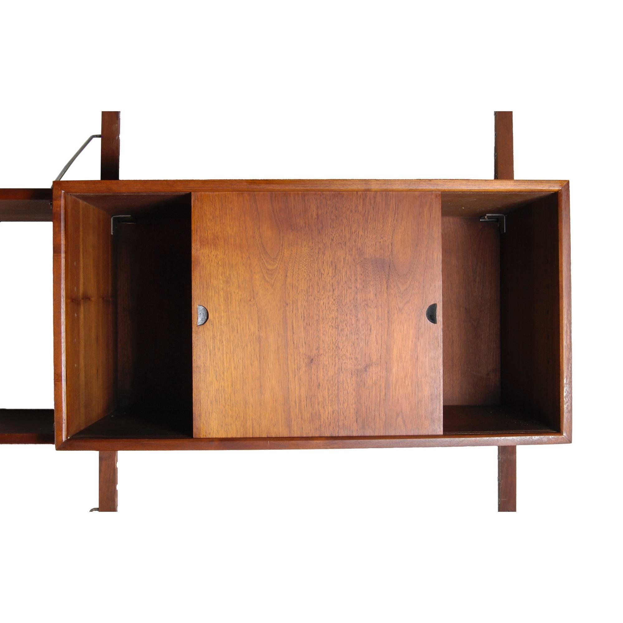 Vintage 1960s walnut wall unit with storage and shelving. Includes shelving, drawer storage, drop-down cabinet and open slotted cabinet. Desk opening is 32