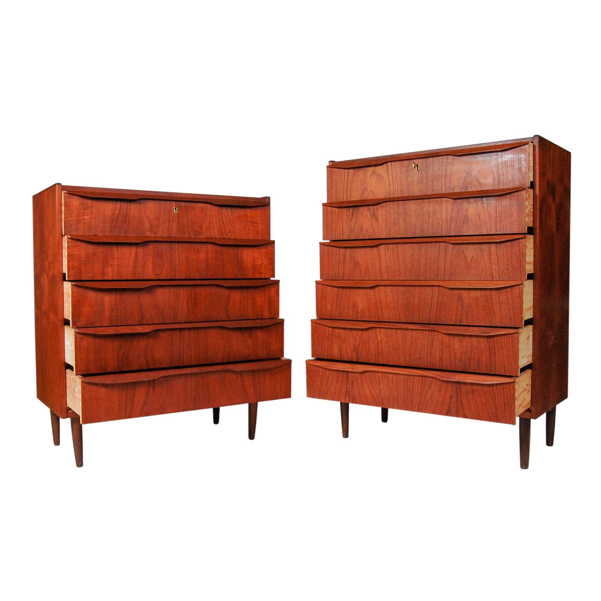 Vintage pair of 1960s Danish teak "His and Her" tall dressers with sculpted wood handles. Each dresser has working locks and a key. Taller dresser has six drawers and the smaller dresser has five drawers. Measures: Smaller dresser: