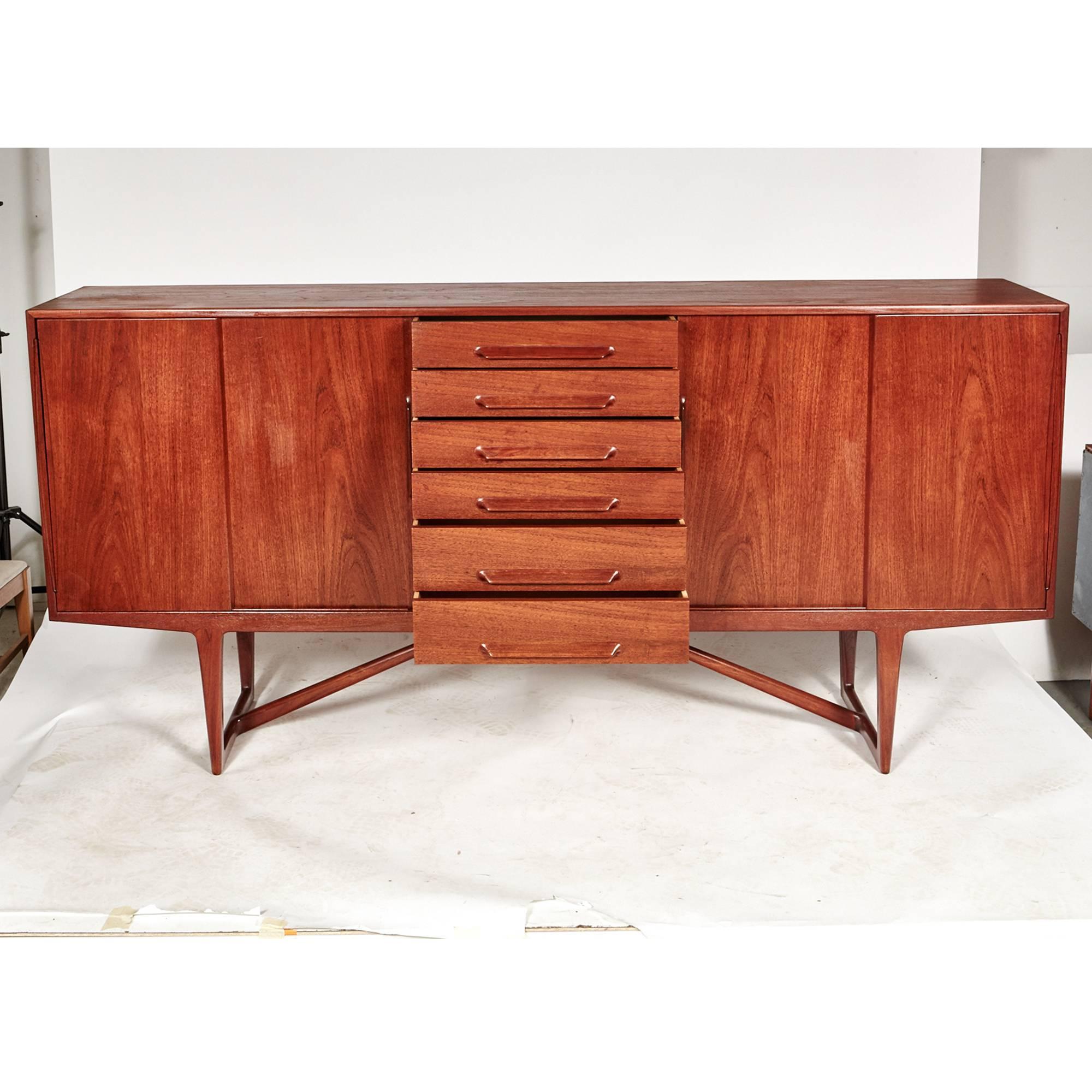Kurt Østervig designed teak sideboard for Brande Mobelindustri in Denmark, early 1950s. Interior has adjustable shelves and six drawers with sculpted handles. Base has a cross stretcher for support. Excellent condition.