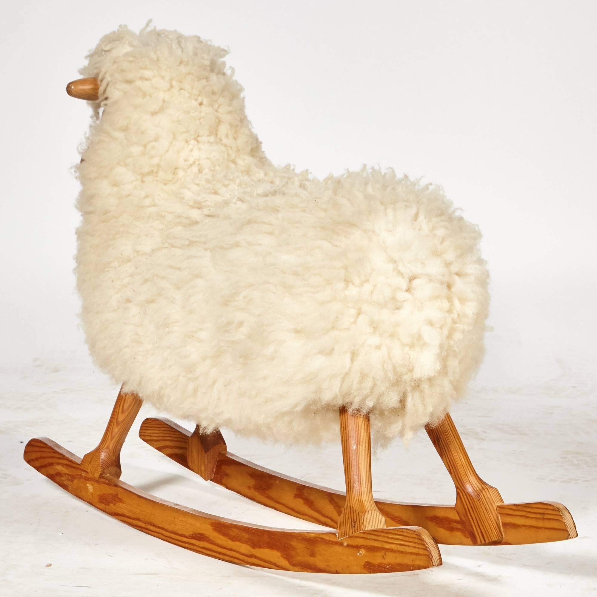 Danish designer Povl Kjer handcrafted child rocking sheep, 1950s. Made with genuine sheepskin and pine wood base, this original designed rocking horse is still made in Denmark today. Marked.