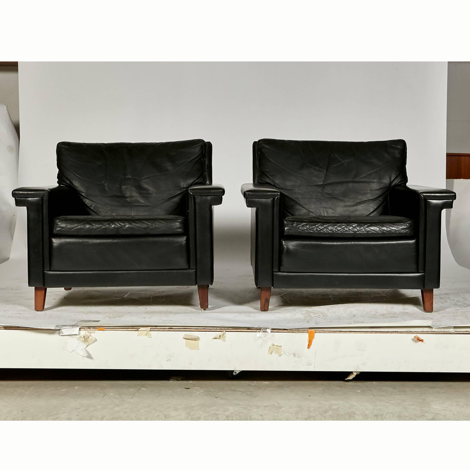 Vintage pair of Danish black leather lounge chairs with Brazilian rosewood feet, 1960s. Arms 20 in.H. No maker's mark.


  