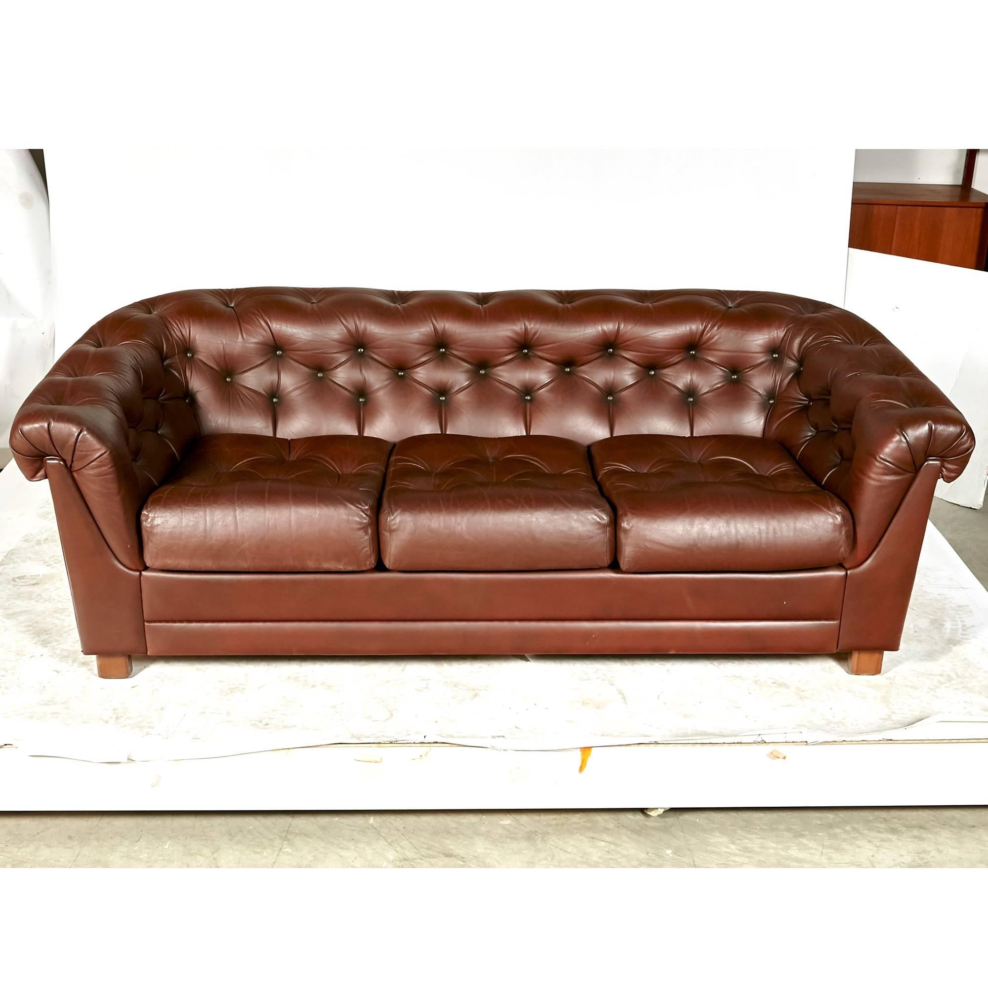 Late 20th century brown leather three-seat Chesterfield sofa with solid wood frame. Arm 24in.H. No maker's mark.


  