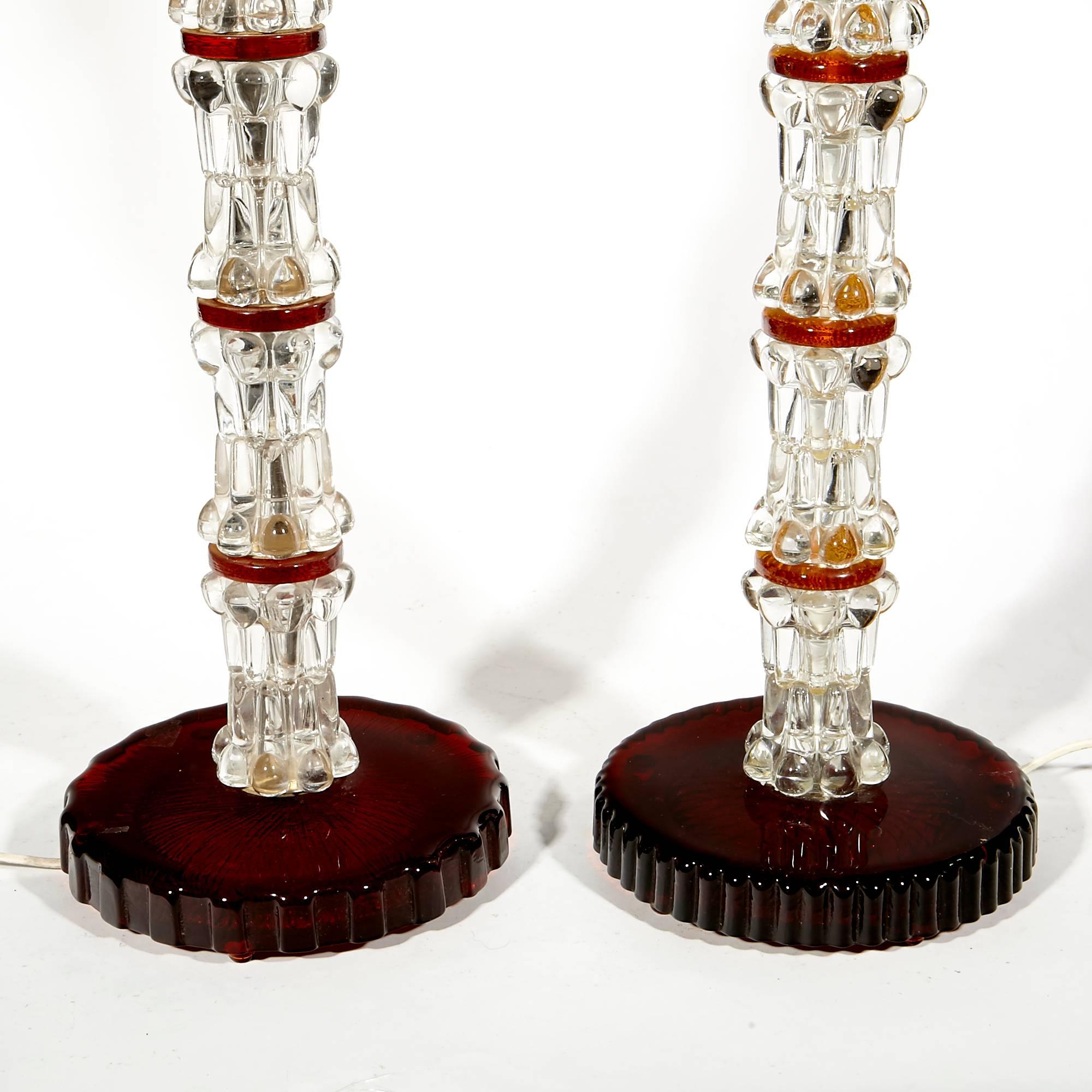 Vintage pair of 1960s Orrefors of Sweden crystal stacked lamps designed by Carl Fagerlund. The lamps have an alternating red glass accent. Uses standard size bulbs. The shorter lamp is 8.5in. Dia x 33.75in. H.

  