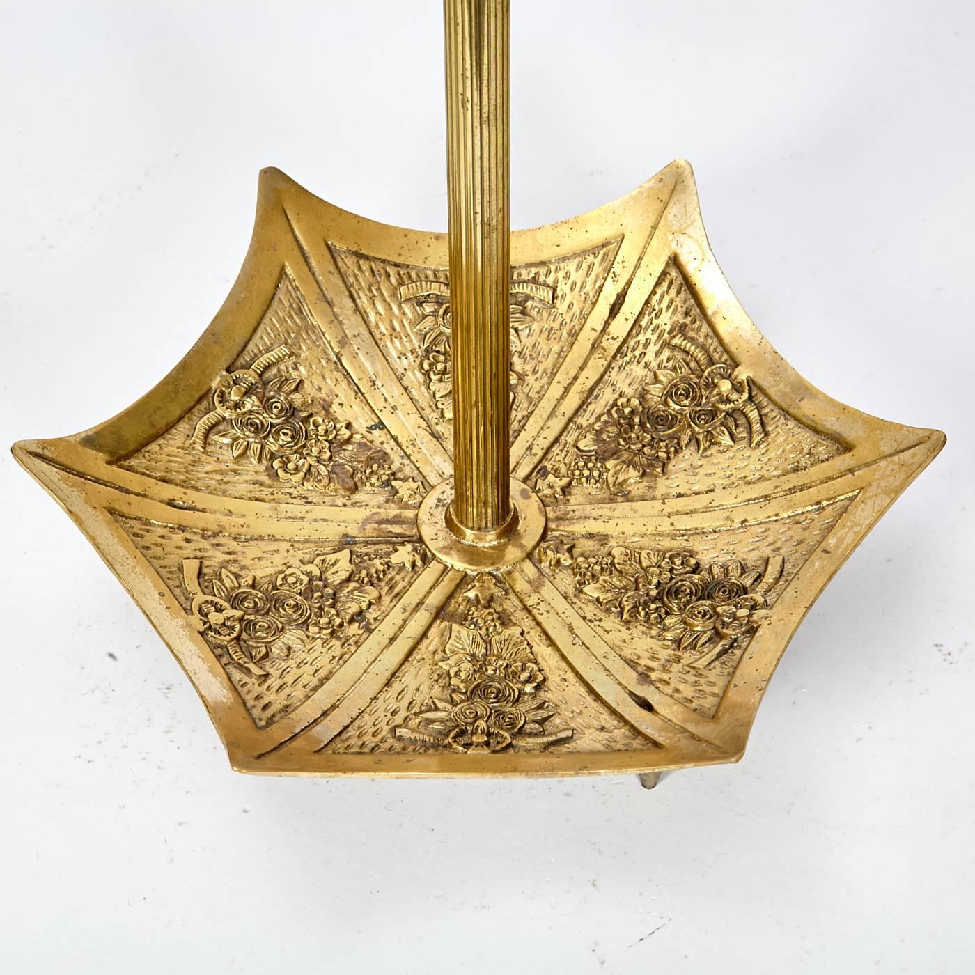 Art Deco style gilt metal umbrella stand with floral and dragon handled accents. Holds five umbrellas and walking sticks. Light wear to base. No maker's mark.