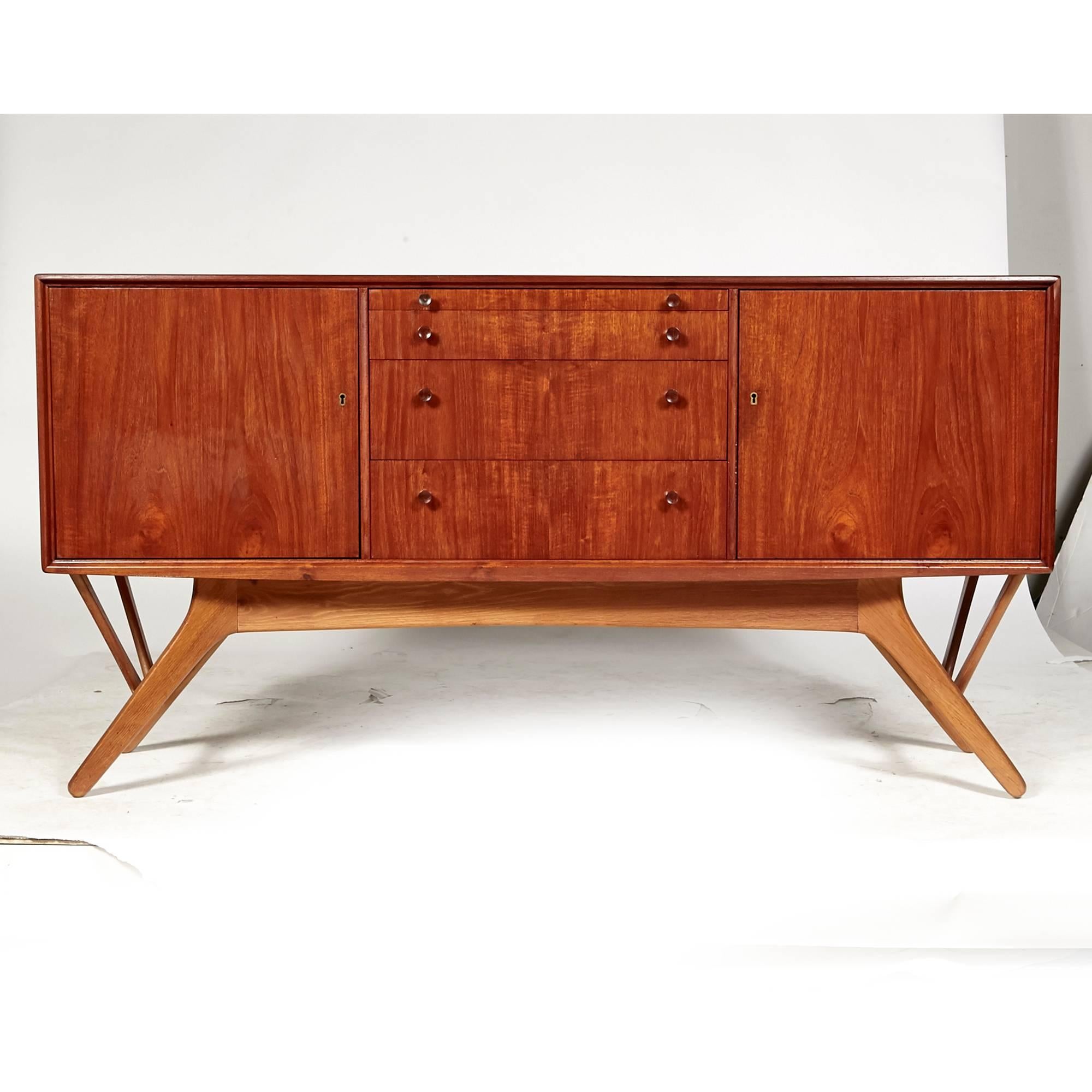Vintage mid-20th century Danish teak and beechwood angled base credenza, circa 1960s. The tall credenza has drawers and shelving for storage, with round teak pulls. The angled base is in beechwood. Unmarked.