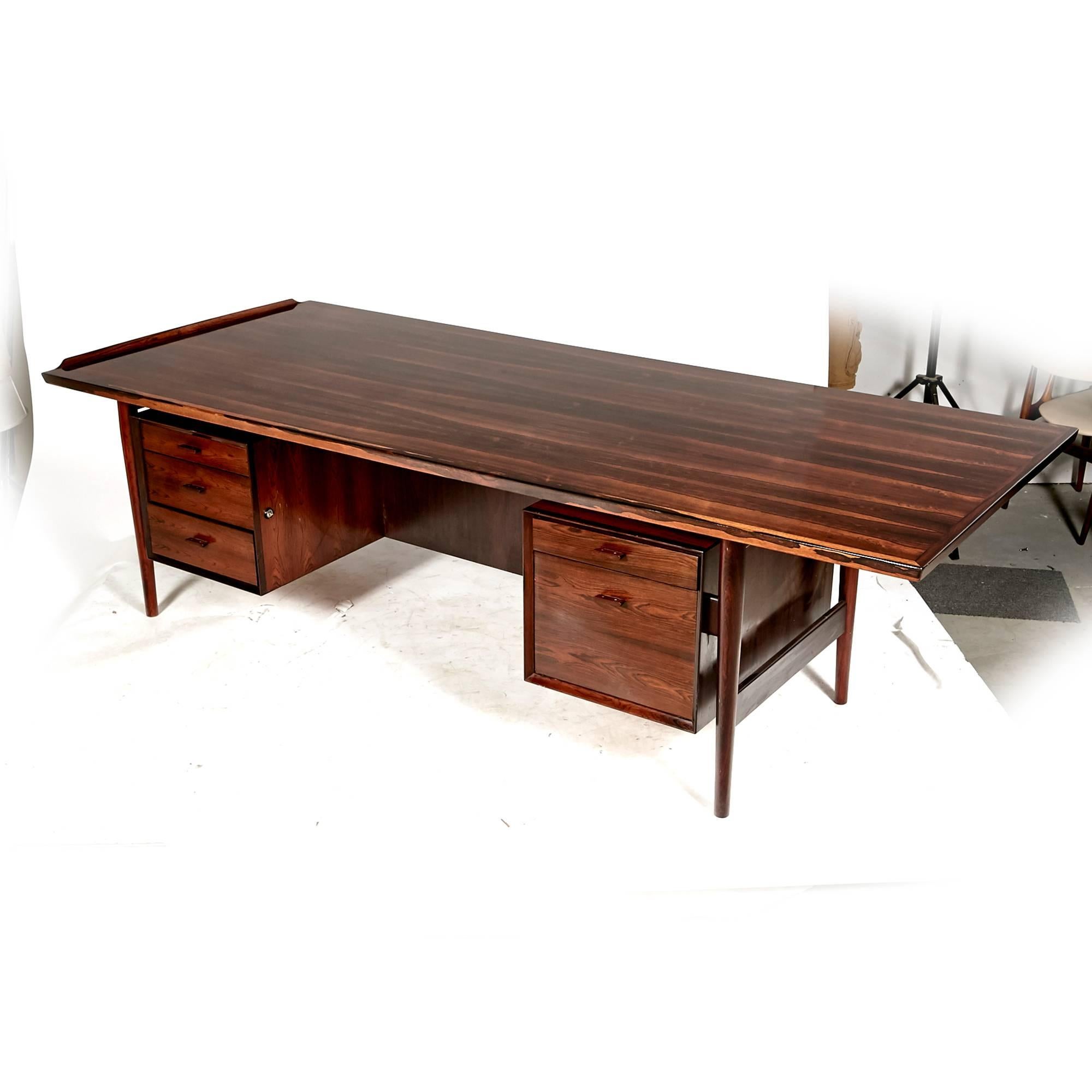 Vintage rare Danish rosewood 8ft Executive desk designed by Arne Vodder for Sibast Denmark, circa 1960s. The desk has five drawers with a curved lip on the sides. Drawers have original separators inside with rosewood drawer pulls and stainless steel