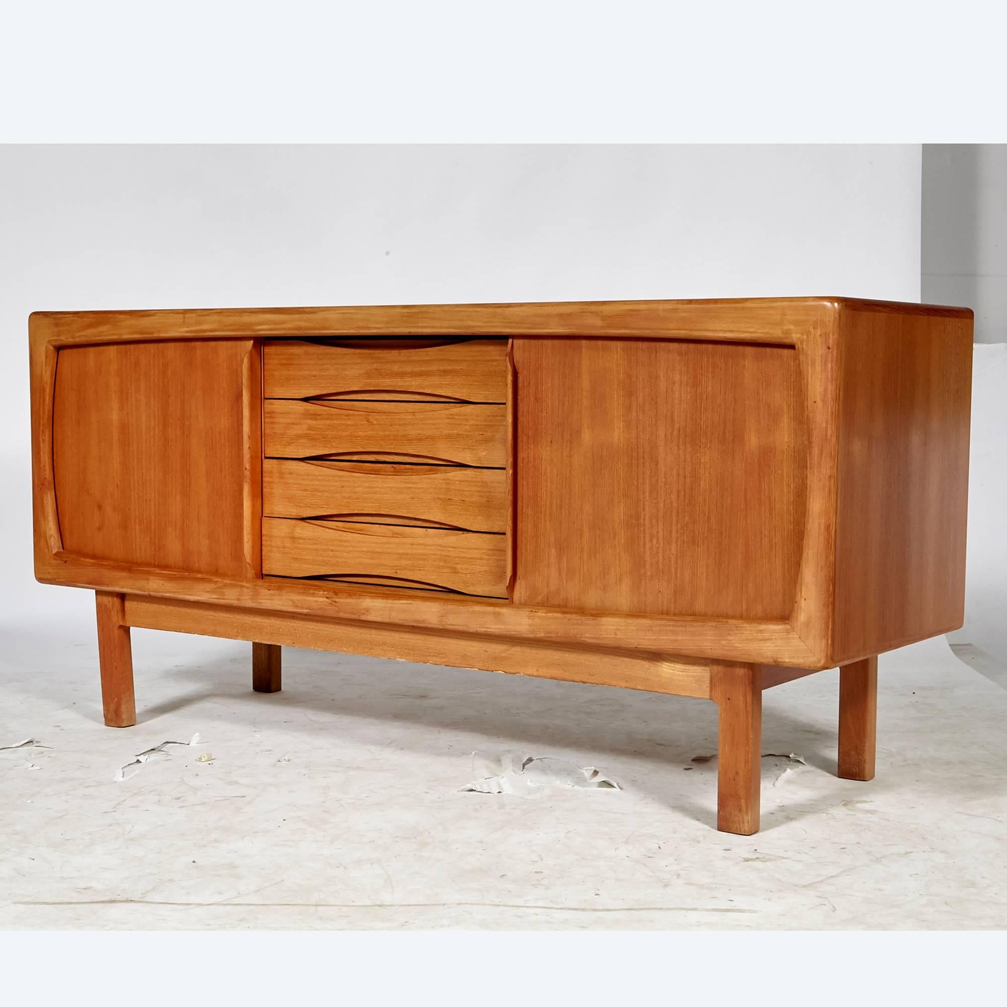 Vintage Scandinavian Modern Danish teak credenza, circa 1985. The credenza has four drawers and shelving for storage with sliding front doors. No mark, but dated on the back.