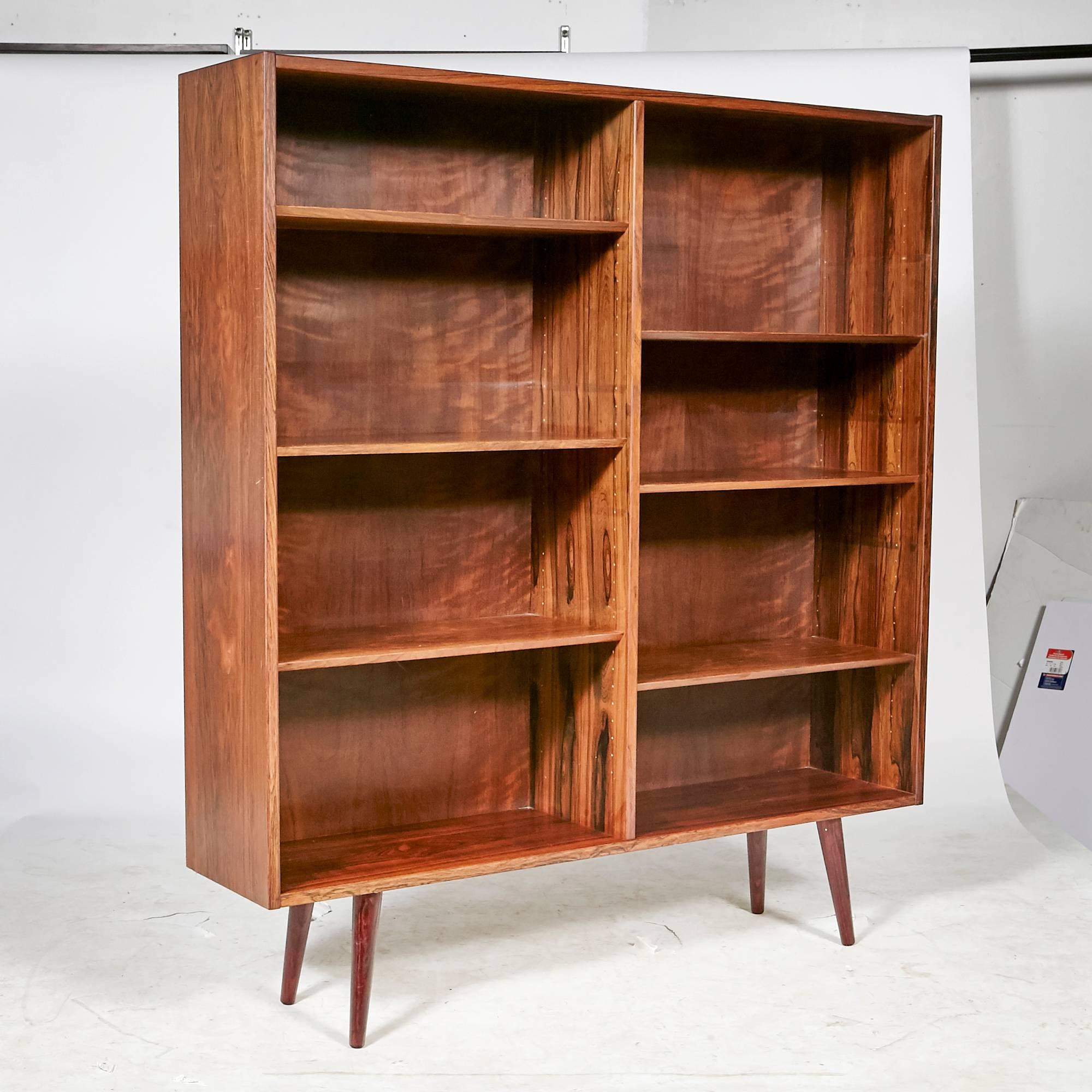 Vintage Scandinavian Modern Danish rosewood bookcase designed by Poul Hundevad, circa 1960s. The shelving is adjustable with round angled legs. Marked.