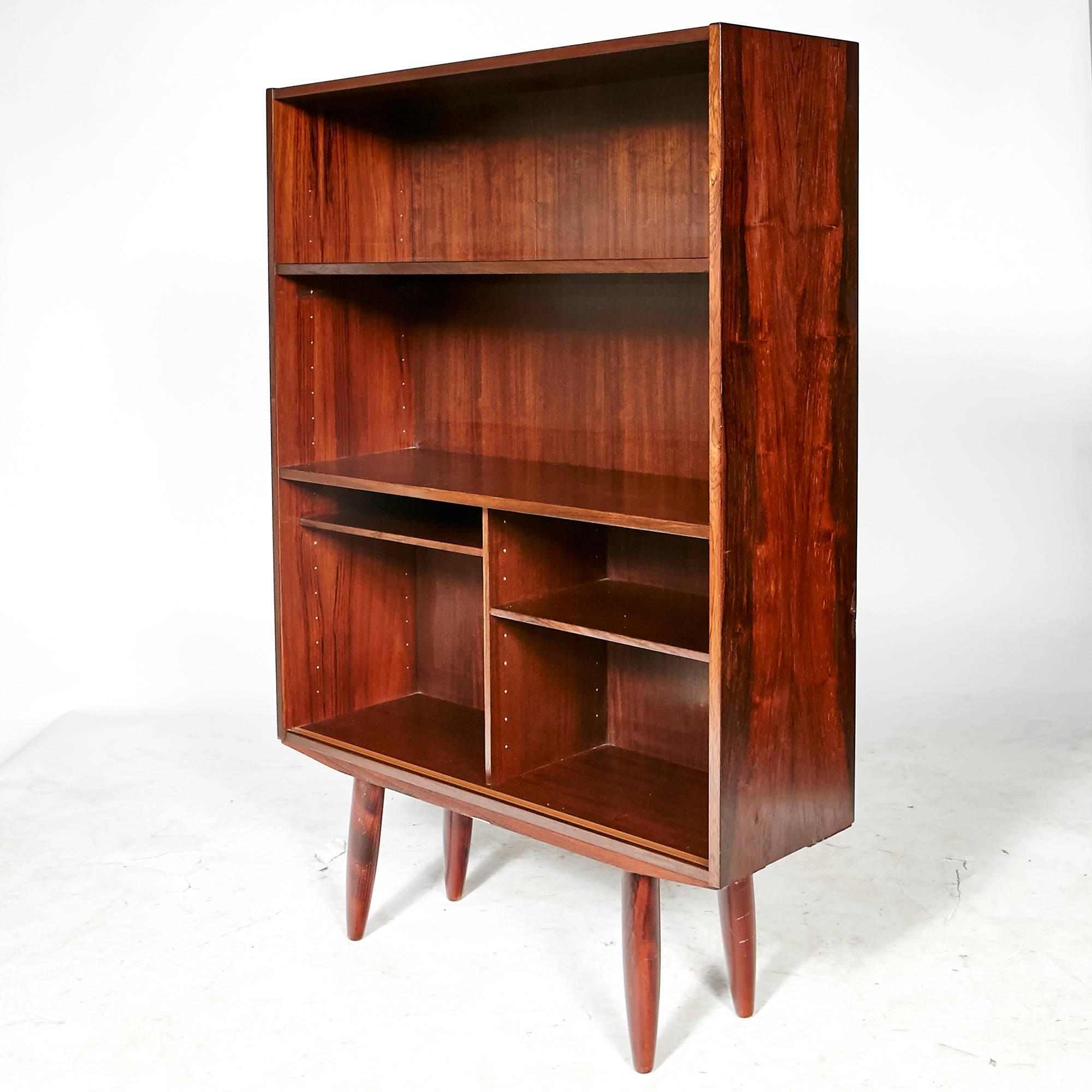 Vintage Scandinavian Modern Danish rosewood small bookcase with adjustable shelving and round angled rosewood legs. Unmarked.