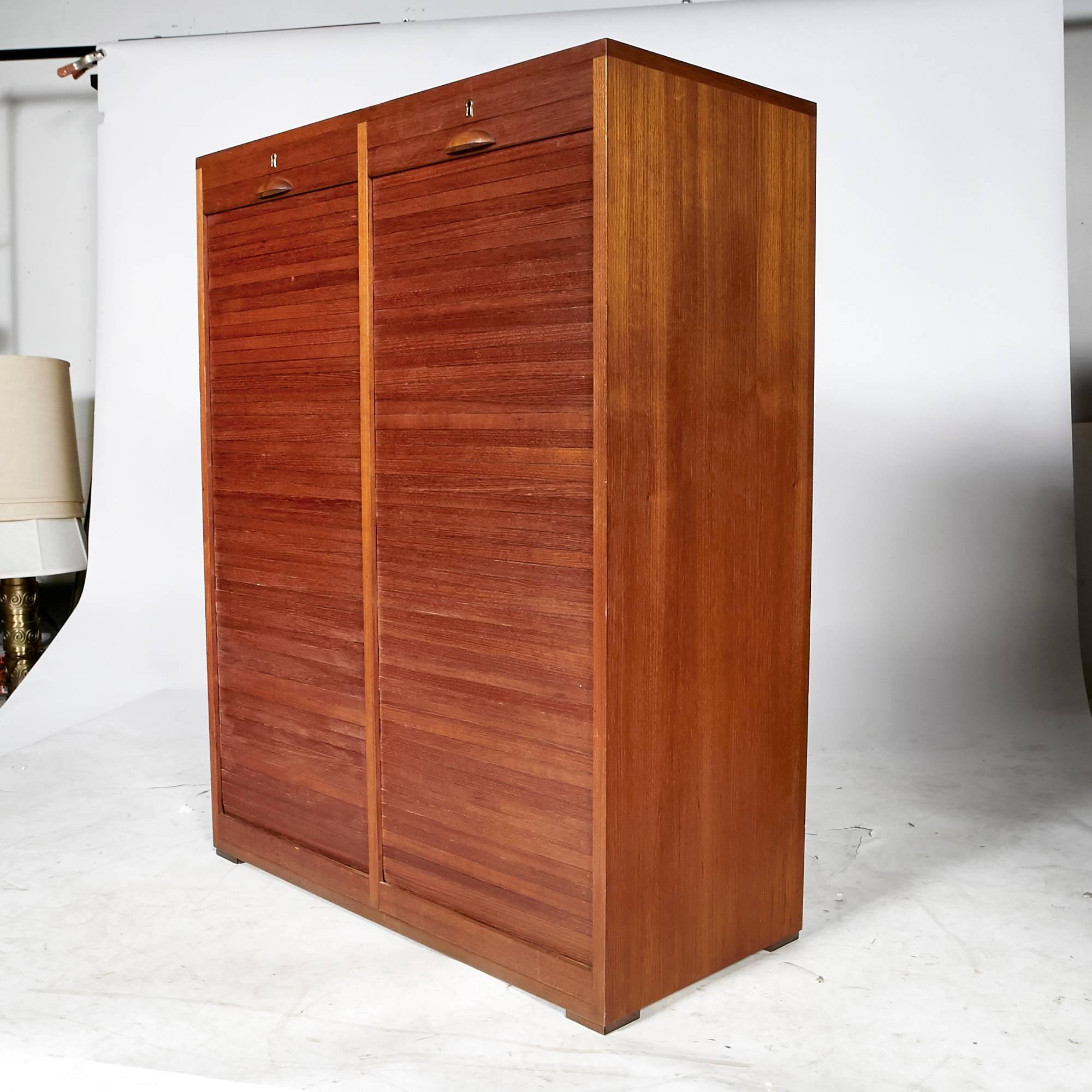 Vintage Scandinavian Modern Danish teak tambour front flat file and storage cabinet by Frej-Odense, circa 1960s. Cabinet features two pull down tambour doors that reveal ten beach wood & birch filing drawers on each side. Includes one locking key.