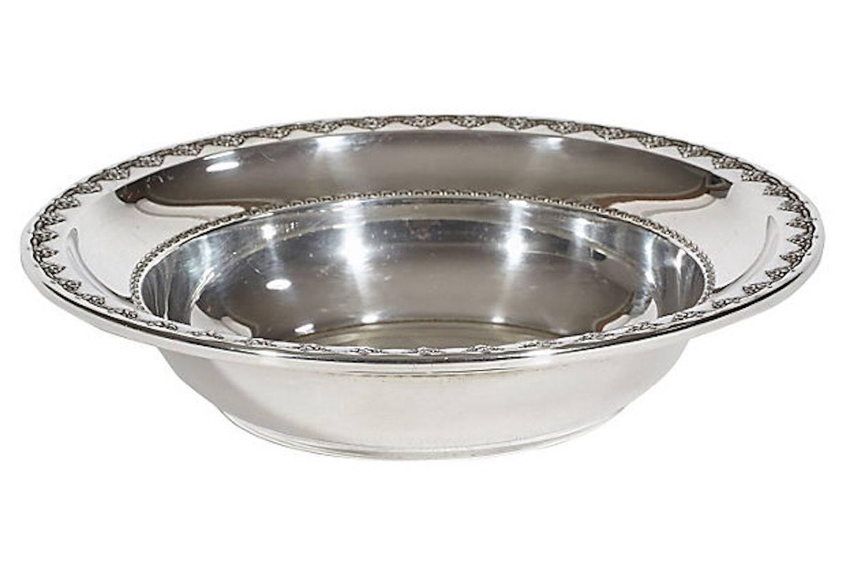 Sterling silver 1946 round table serving bowl with a repeating grape designed rim by Reed & Barton, Taunton, MA. 9.65 Troy ounces. Marked underneath.