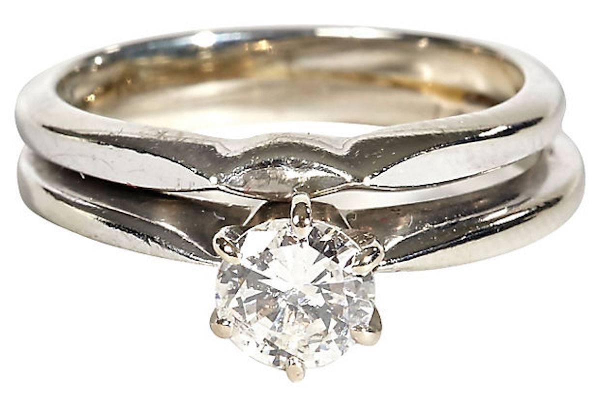 Ladies 14-karat diamond engagement and attached wedding band. Engagement ring contains a round brilliant cut diamond set into a six-prong white gold head with a white gold shank. Approximate diamond weight: 55 Ps. Color grade: G-H. Clarity: SI. Ring