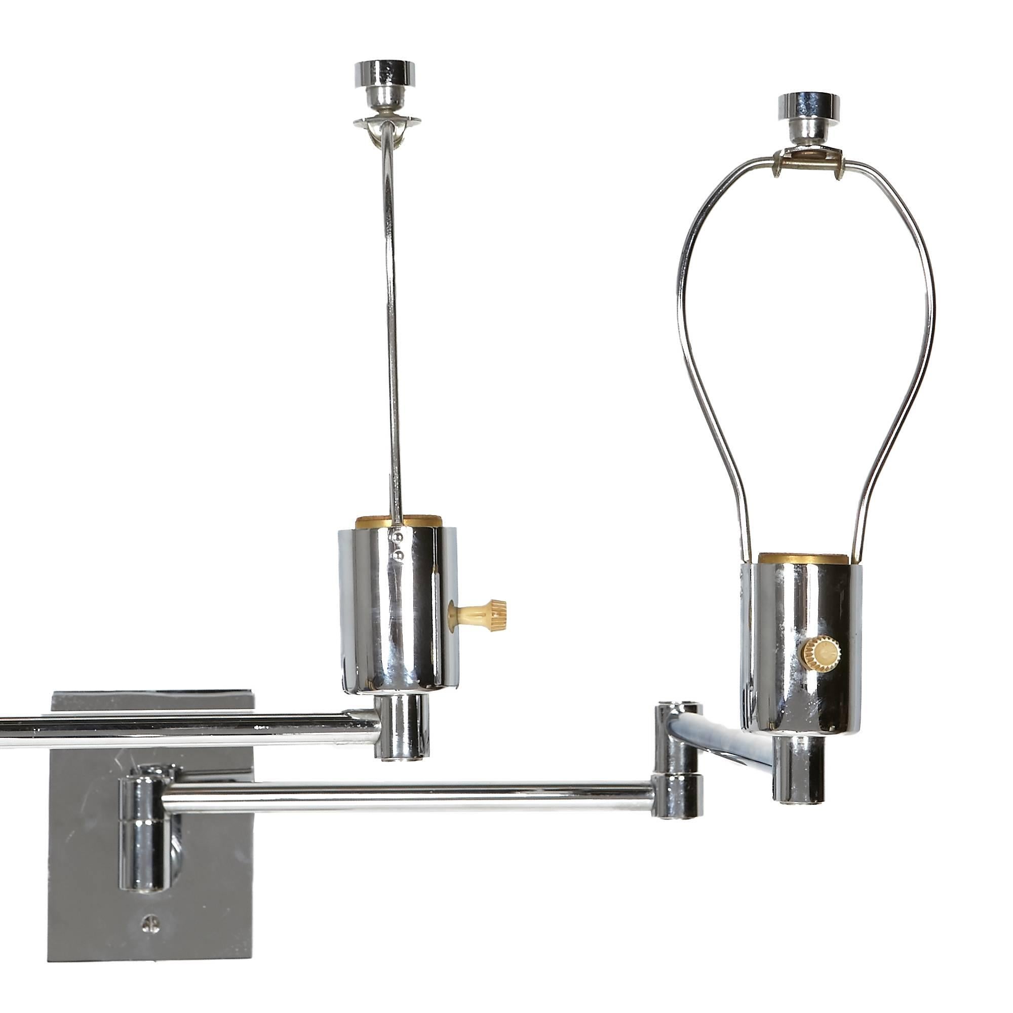 Pair of chrome wall mounted swing arm lamps designed by Georg W. Hansen. Chrome wall mount plate is 3.5"L x .5"W x 4.5"H and has the original finials. Uses a standard bulb up to 100W. Does not include column cord covers, but can be