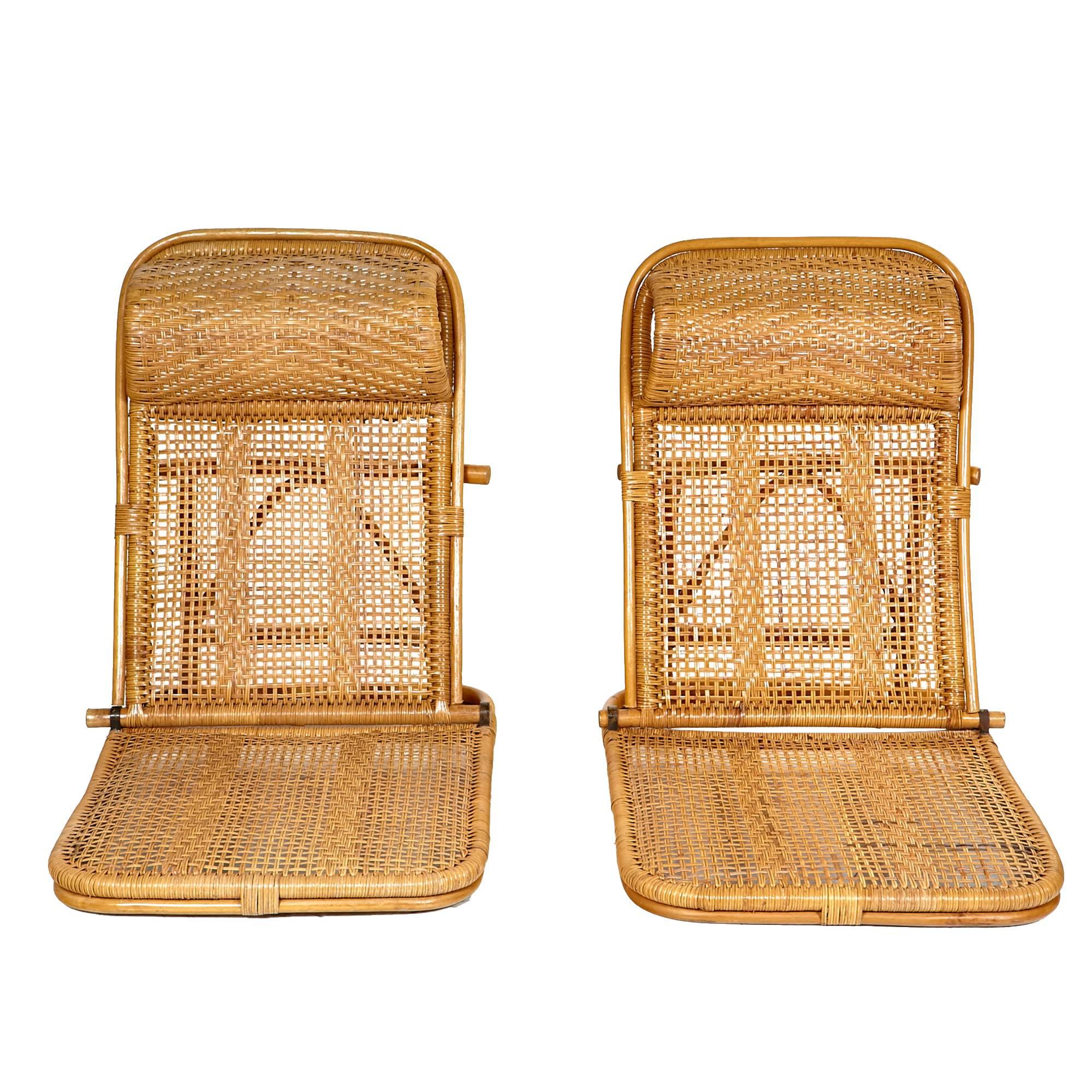 Mid-20th century pair of rattan and wicker folding beach chairs with built-in headrests. The chairs have a flat seat and two adjustable back positions; straight up and reclining angle. The chairs fold flat for storage. Excellent condition. Unmarked.