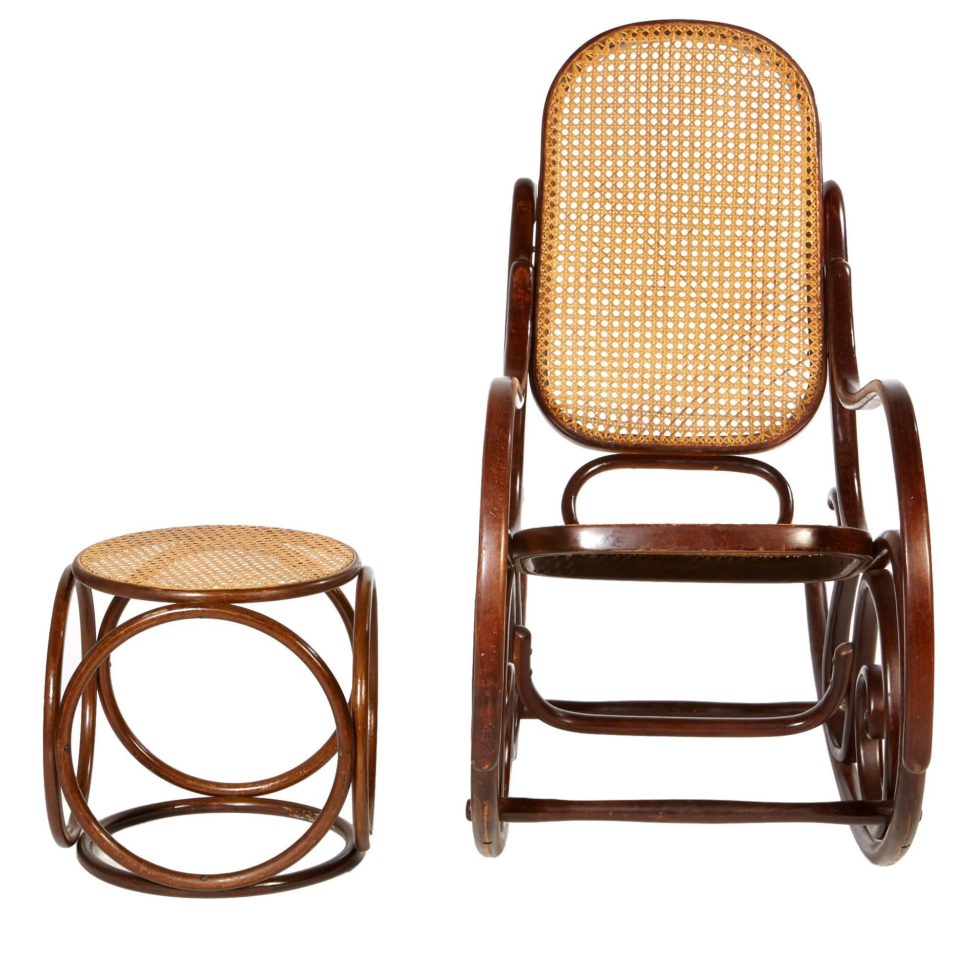 Mid-20th century Michael Thonet style caned rocking chair and matching ottoman with a dark mahogany stain. Rocker and ottoman have caned seats and circle accents. Ottoman dimensions: 15.25" D x 15.25" H.