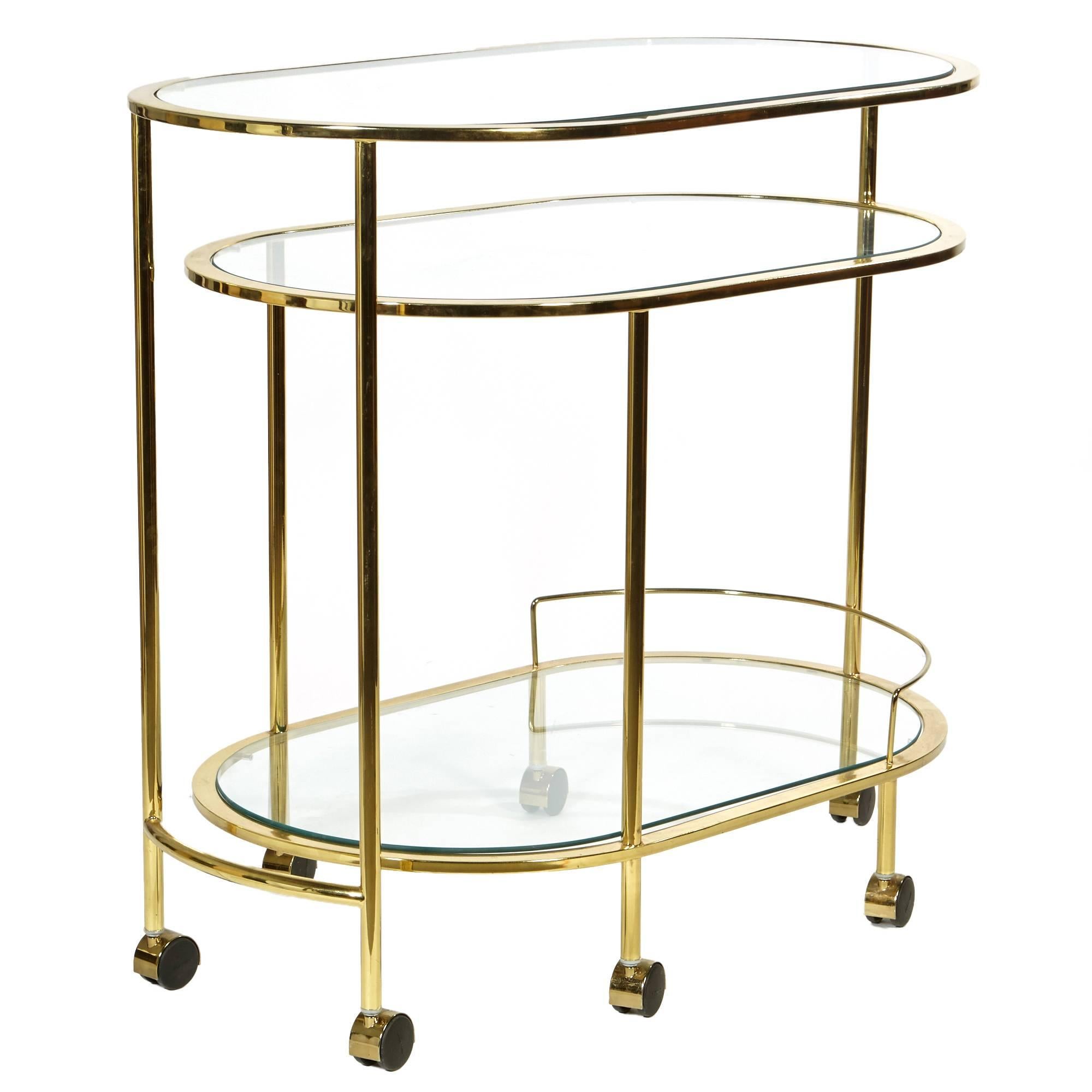 The 1970s swivel brass and glass top rolling serving cart. Bottom section swivels out to create a two-part serving cart. Excellent condition. Fully opened: 70.5