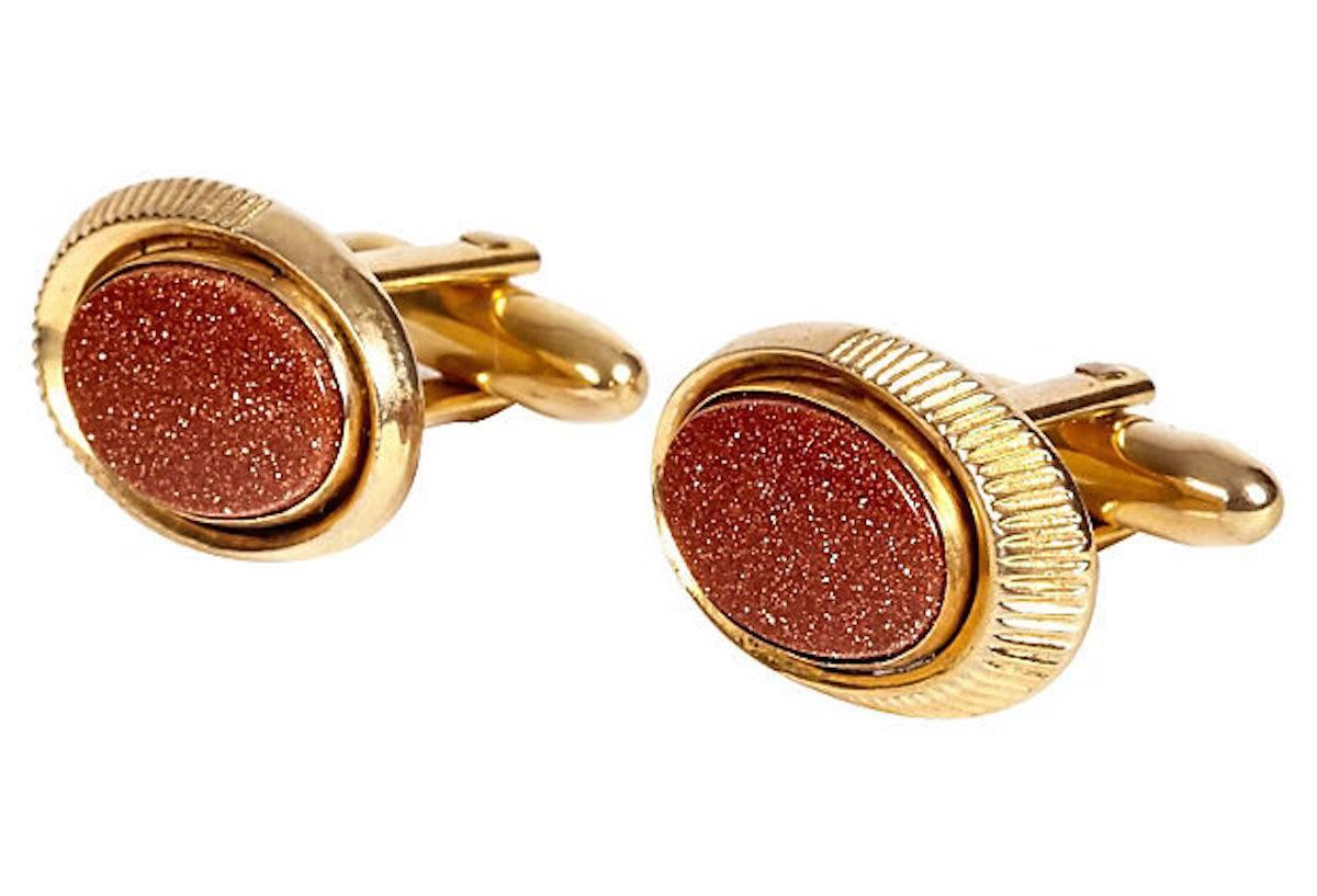 Pair of 1960s men's oval gilt metal and red thermoset cufflinks. Marked: "Speidel."