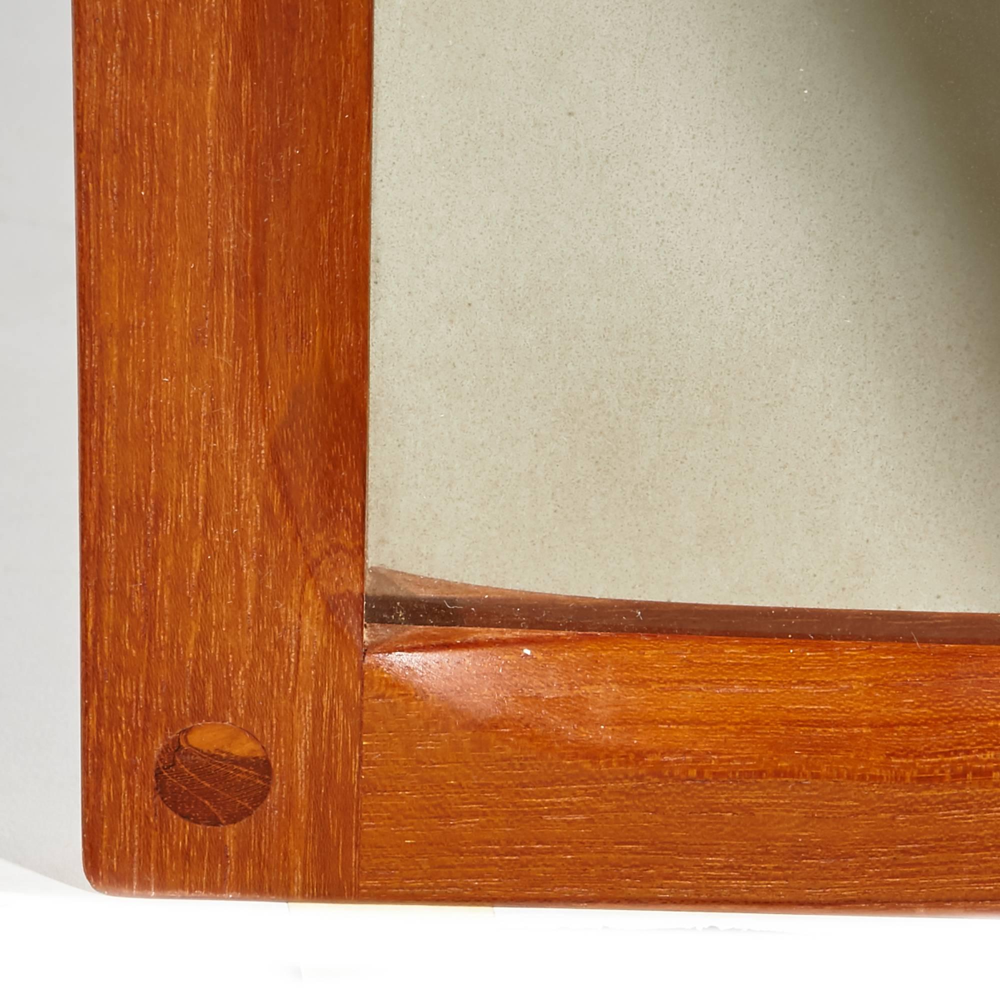 Vintage 1960s Aksel Kjersgaard teak mirror by Odder of Denmark. Dovetailed joints. Mirror is very good condition with minor fogging. Brackets are included. Marked.