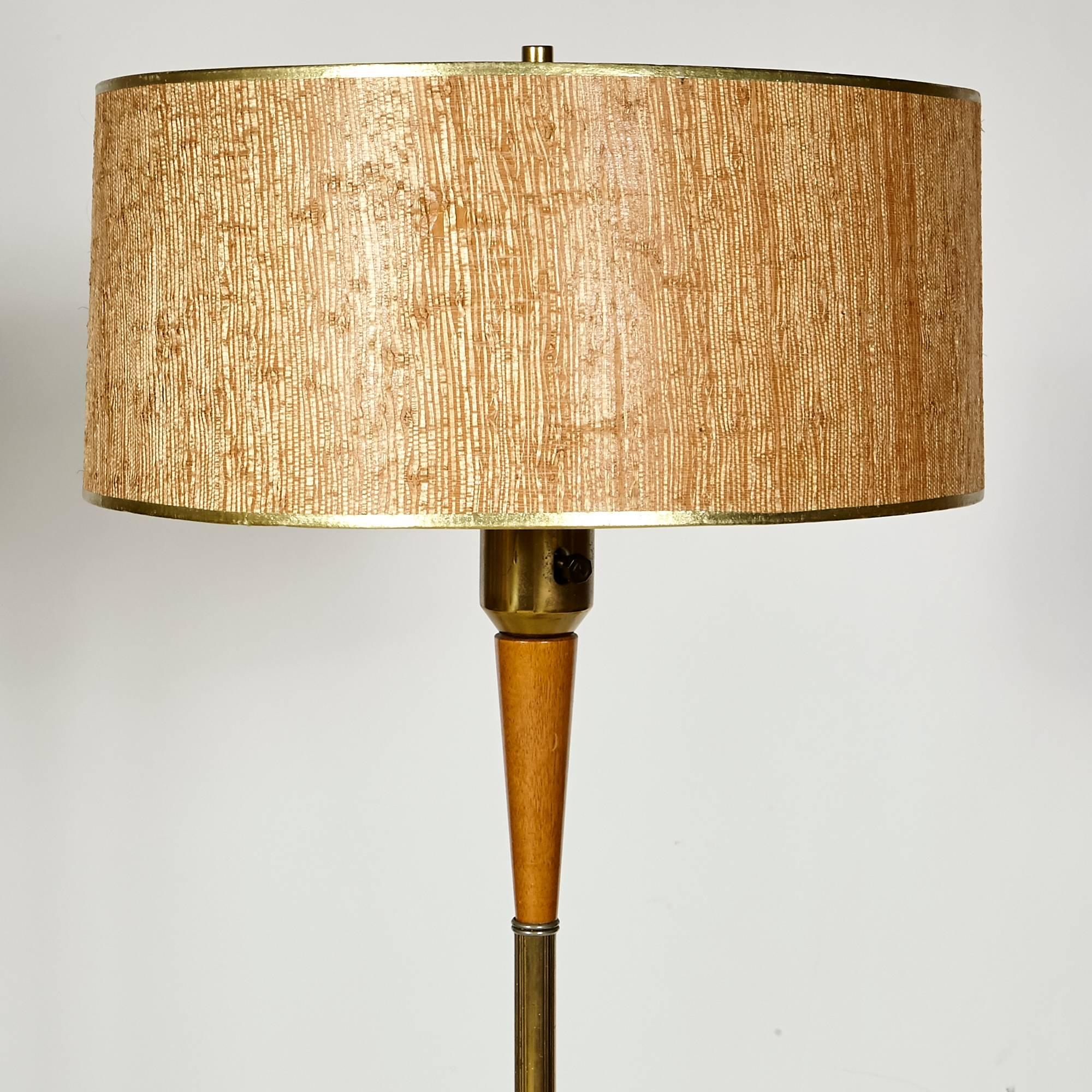 Mid-20th century Gerald Thurston for Lightolier brass and walnut wood floor lamp with the original grass shade. Wired for the US and in working condition. Uses standard size bulbs.
 