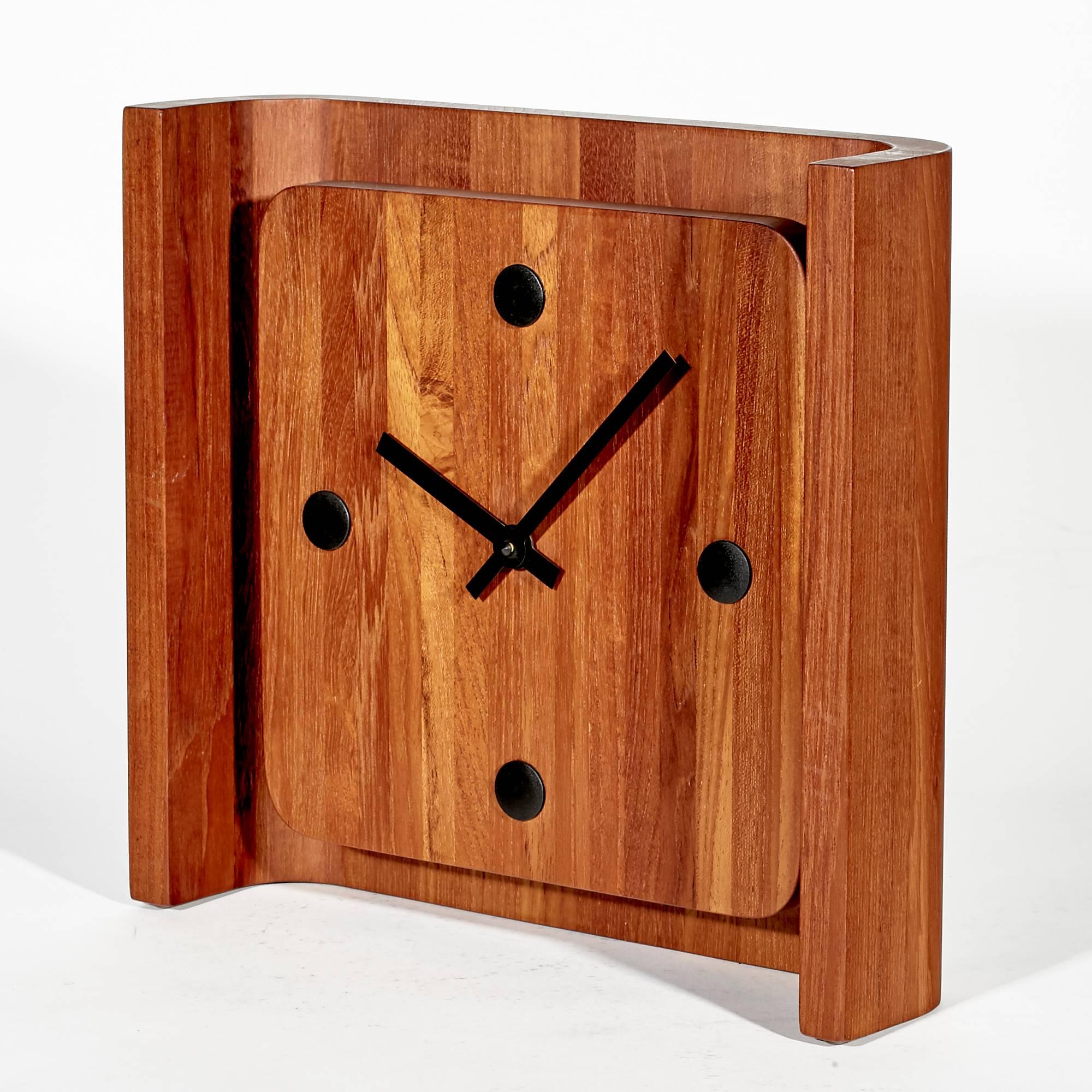 Vintage 1970s Danish teak clock with a curved back. Clock can sit or be hung. Uses a AA battery, has been tested and is in working condition. Marked Denmark on the back.
