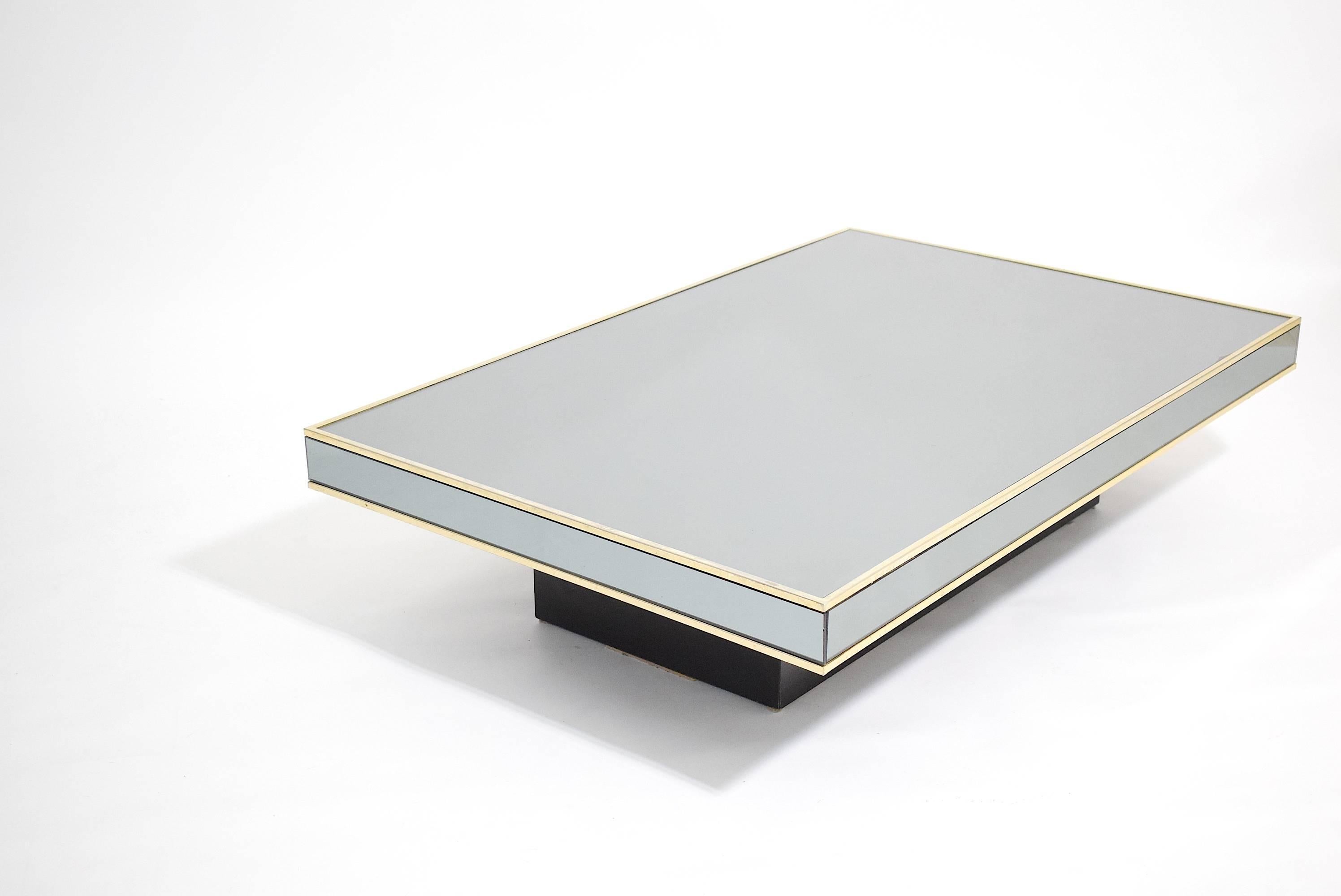 A stunning and large cocktail table with grey tinted mirrored surfaces, brass edging and black laminate base.

Designed in the 1970s by Willy Rizzo for Italian furniture makers Cidue.

Cidue sticker to base. 

We can provide worldwide shipping