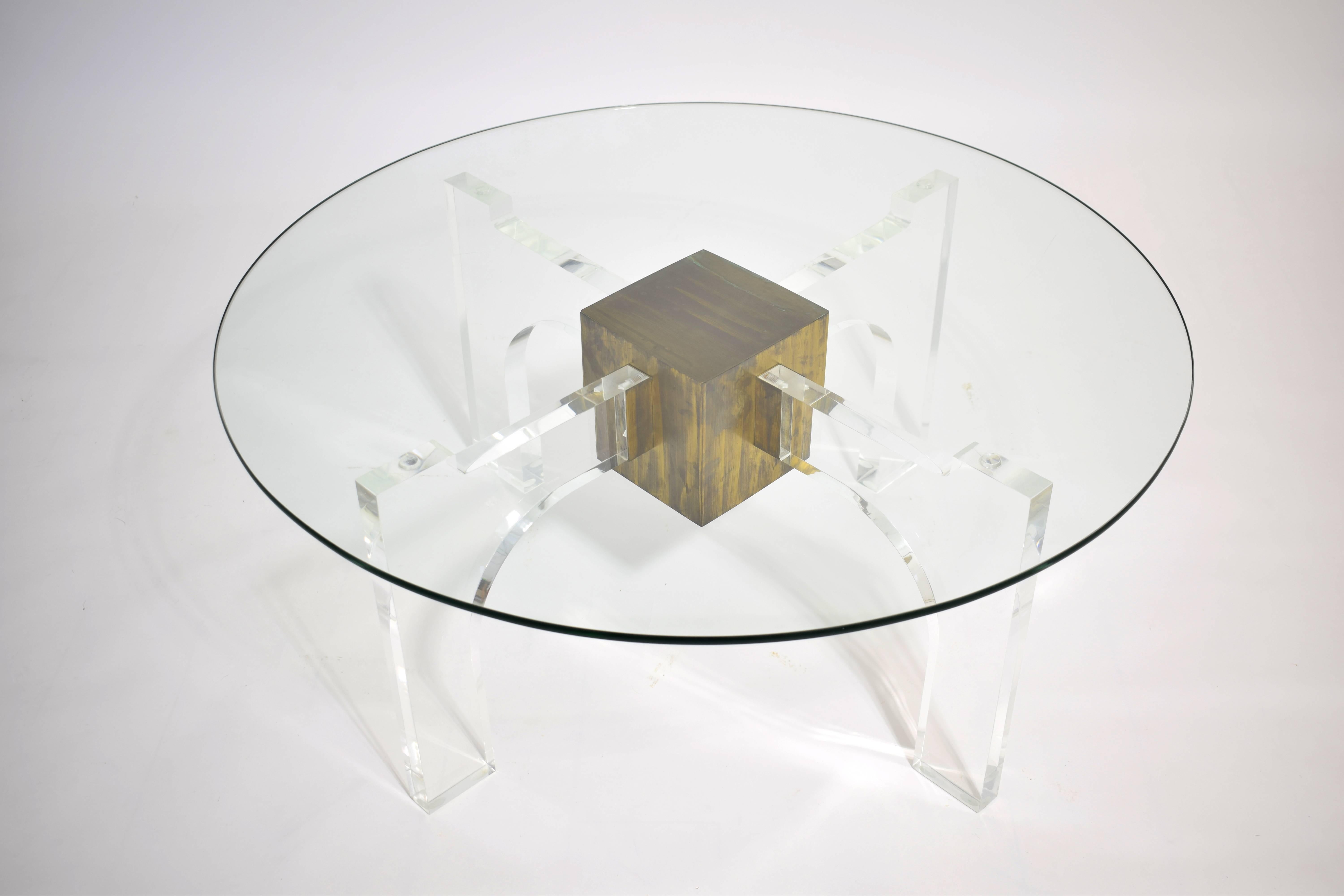 Gorgeous 20th century cocktail table with thick Lucite base, central patinated brass cube and quality glass top.

Please contact us directly for an international shipping quote.
