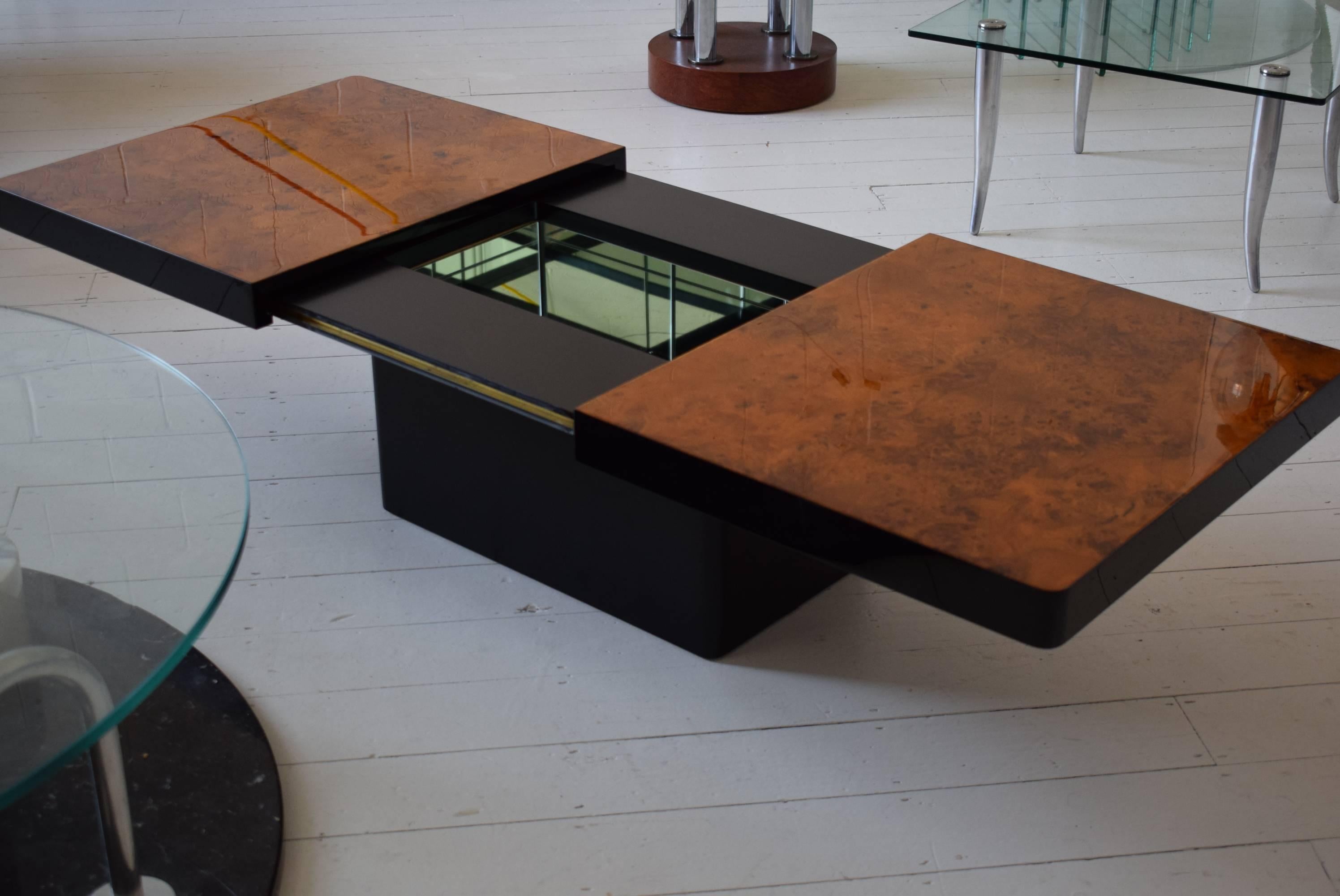 Beautiful 1970s Italian coffee or cocktail table with high gloss extendable burl walnut top, black lacquered body and internal mirrored dry bar. Lovely brass runners.

Please message us directly for a global shipping quote.