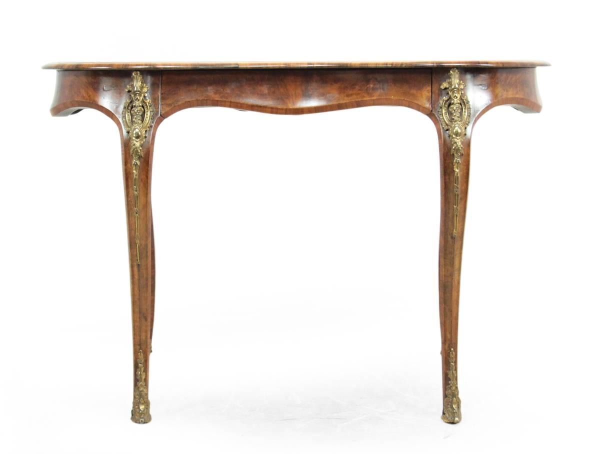 Kidney shaped ladies writing table, circa 1860.
A walnut kidney shaped writing table with serpentine legs, adorned with ormolu mounts. This was produced in French style in the circa 1860s from solid mahogany with walnut veneer. The top of the desk