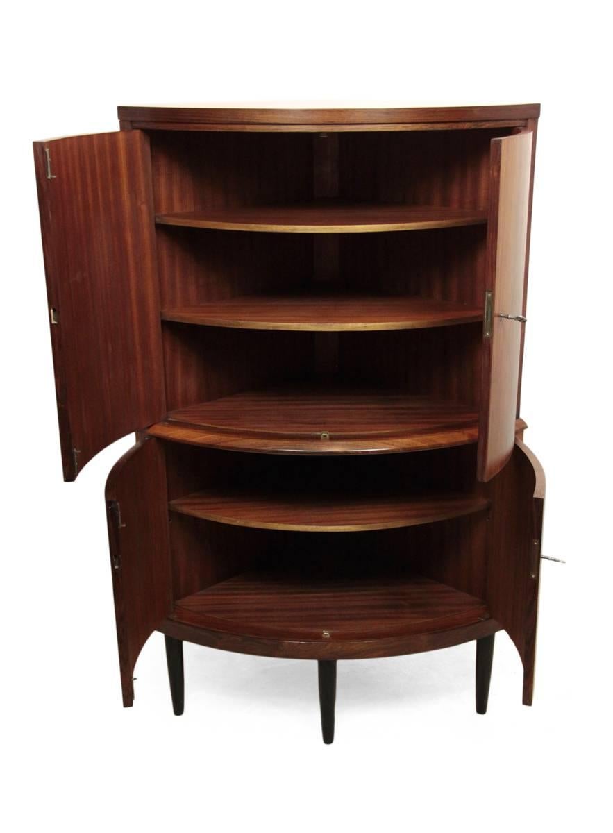 Danish rosewood corner cupboard by O Bank Larsen.
Produced in Denmark in the mid-1950s by O Bank Larsen, this corner cupboard is in excellent original condition, having four bow fronted doors inset locks and original keys, adjustable shelving