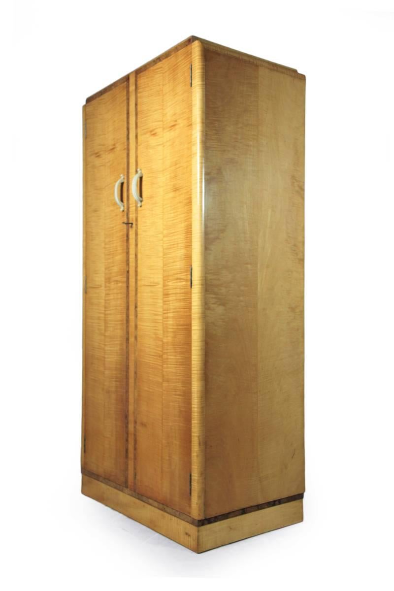 Art Deco wardrobe in Sycamore, circa 1930.
A Sycamore and walnut detail blonde wardrobe, good proportions fitted inside, bake lite handles original key.
Age: 1930.
Style: Art Deco bedroom Furniture.
Material: Sycamore.
Condition: Very