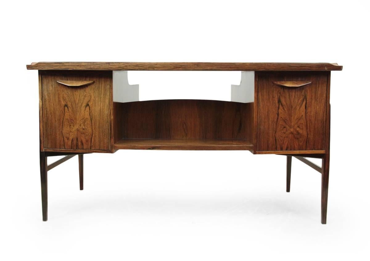 Danish rosewood desk by Sven Madsen, circa 1960.
A Mid-Century Danish rosewood desk by Sven Madsen, six drawers to the front and two drop down door cupboard to reverse dry bar to left and shelves with drawers to right, free standing.
The detail in
