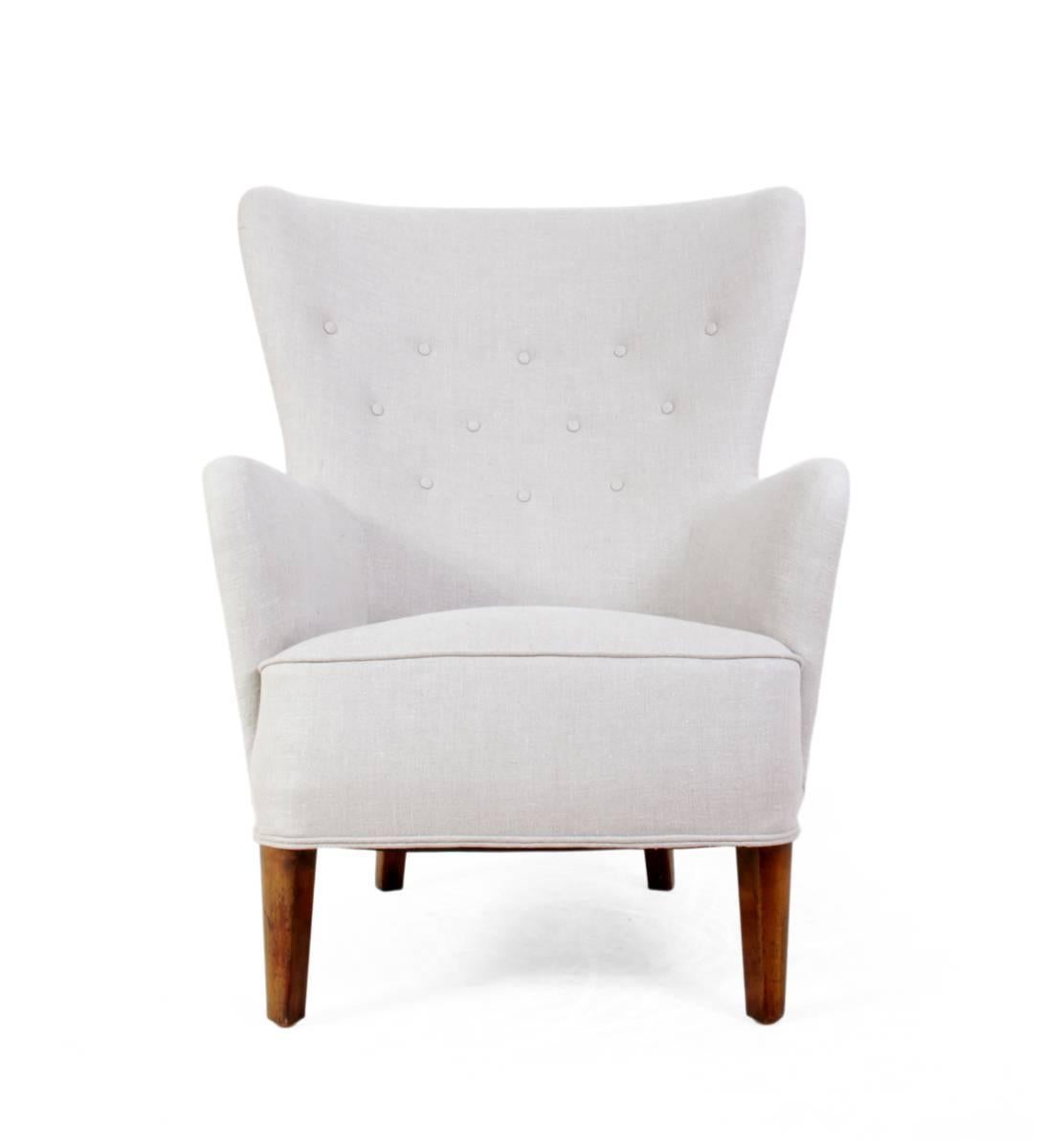 Danish wing chair, circa 1940.
A very high quality fully coil sprung, wing chair. Re-upholstered in heavy weight linen upholstery fabric, solid hard wood frame, webbed and sprung with horse hair filling, buttoned curved back and piped detail.
Age: