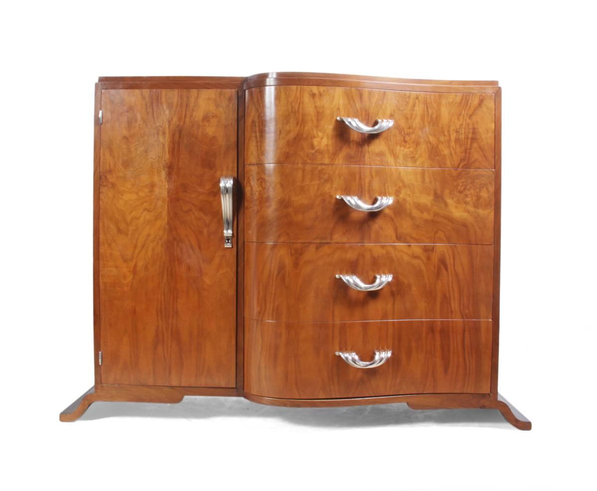 Art Deco walnut side cabinet, circa 1930.
Produced in France in the early 1930s this side cabinet has four drawers to the right and a cupboard to the left all with sculpted nickel-plated handles, this sideboard has been fully restored and is in