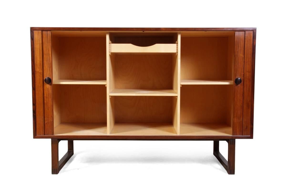 
Rosewood Tambour door sideboard by Soborg, circa 1960.
A good small rosewood sideboard with sliding tambour doors having adjustable shelf interior with small finger jointed drawer at top in excellent condition throughout.
Age: 1960.
Style: