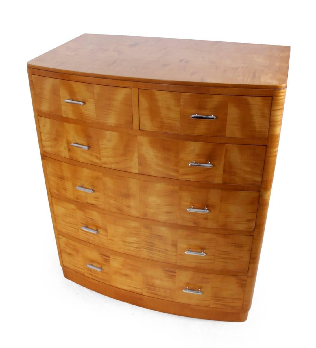 Art Deco satin birch chest of drawers, circa 1930.
This two over four bow fronted chest of drawers was produced in England in the late 1920s or early 1930s from solid mahogany with stunning satin birch veneer, hand cut dovetail joints and chrome