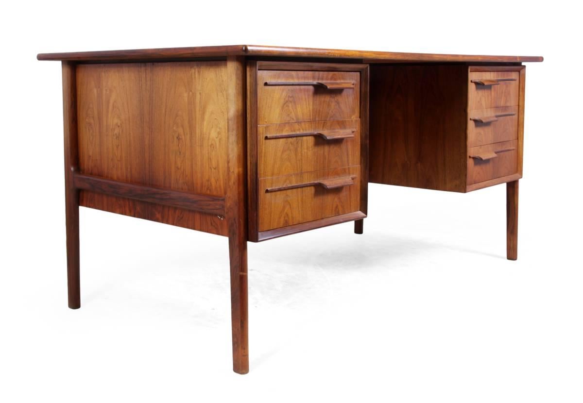 Mid-Century desk in rosewood.
This Danish Mid-Century desk is in excellent condition throughout with six drawers to the front and two lockable drop down doors on the back.
Age: 1960.
Style: Mid-Century Modern.
Material: Rosewood.
Condition: