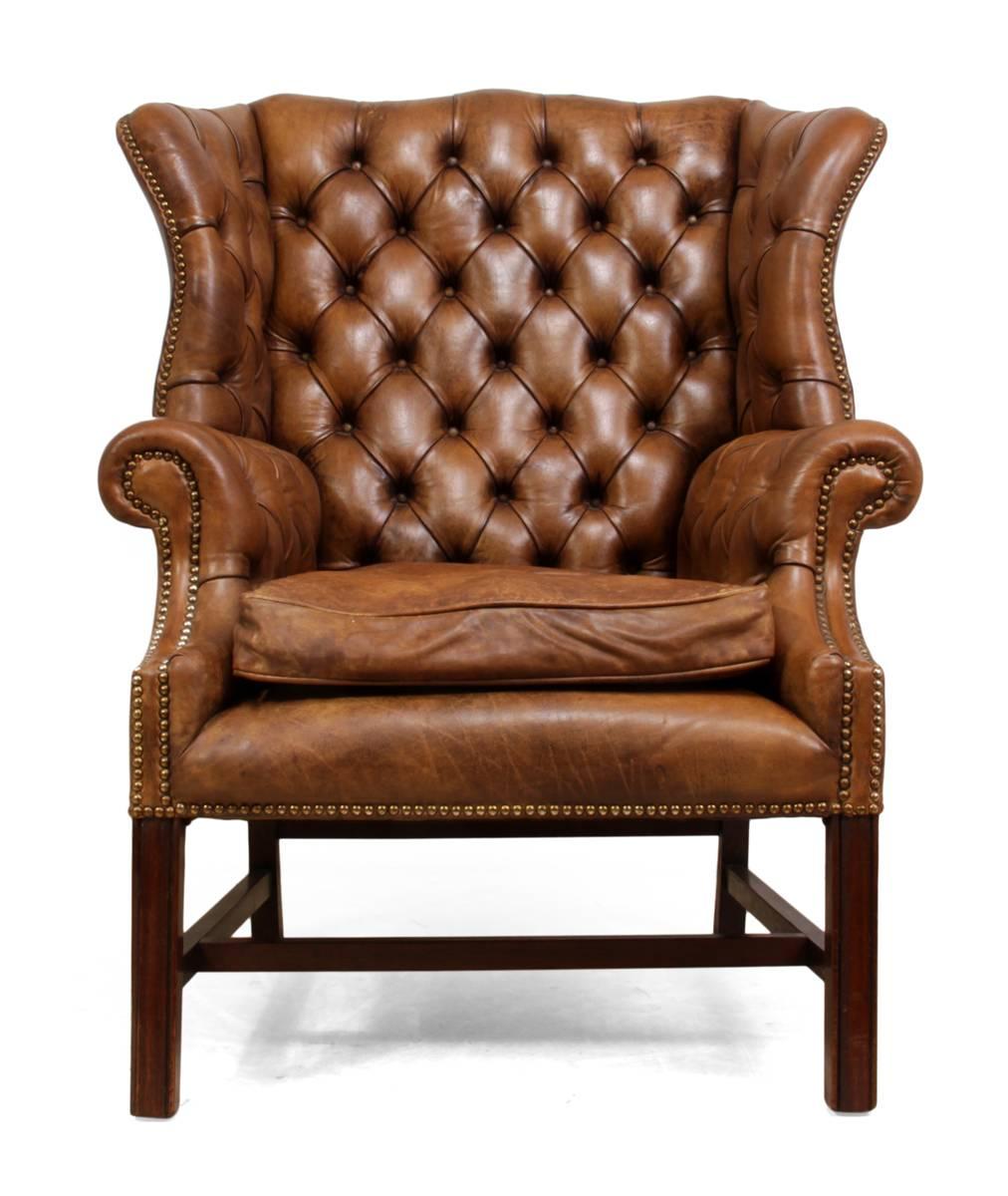 Vintage leather wing chair.
This leather wing chair was produced around the 1960s it has a solid Mahogany frame and tan colored hide upholstery. The seat cushion is down filled, there are two small professional repairs to the leather that are