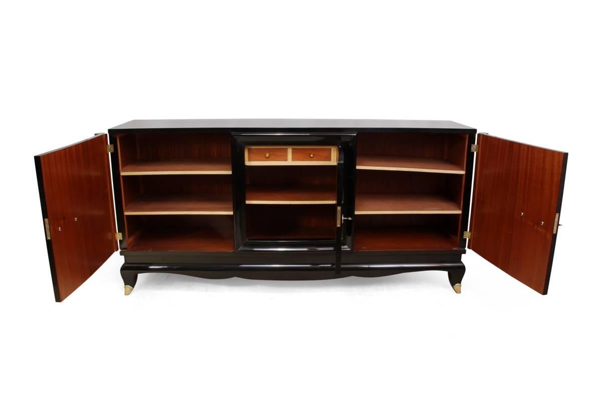 French Art Deco black sideboard, circa 1920

This French Art Deco sideboard in the manner of Jules Leleu has had a black ebonised polish piano finish, it has three doors that are lockable with two keys supplied, high quality brass fittings, the