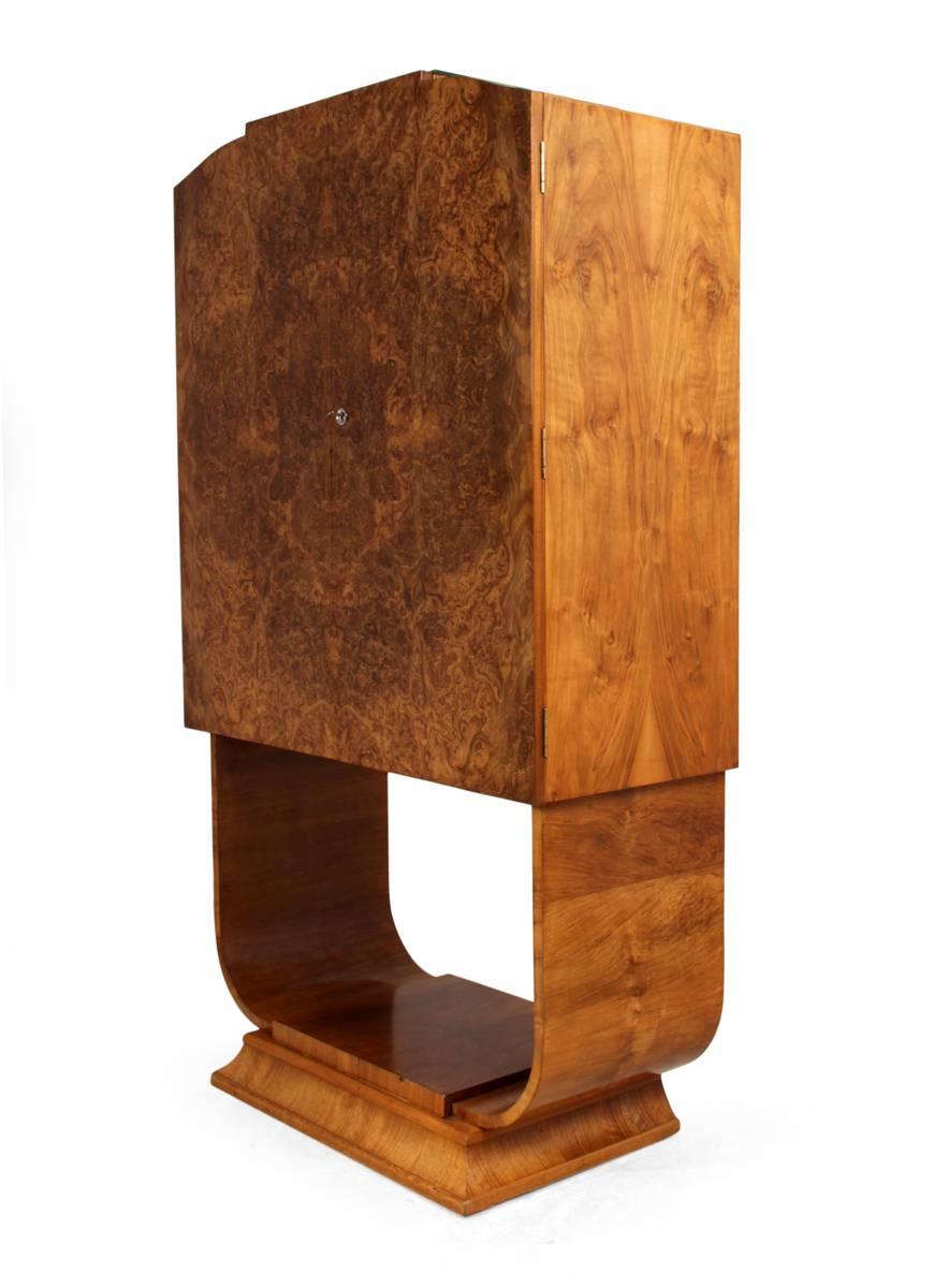 Art Deco cocktail cabinet in burr walnut by Hille.
This cocktail cabinet was produced in the 1930s by London cabinet makers Hille, it has the u form base, burr walnut doors, sycamore lined and mirrored interior the cabinet lights up when opened, it