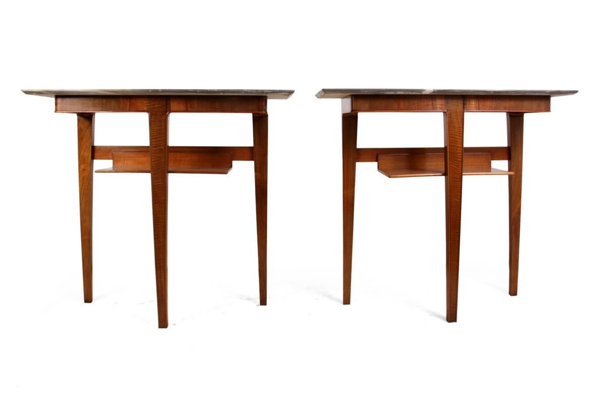 A pair of midcentury walnut console tables.
This pair of Italian Console tables were produced in the 1950s with a simplistic three leg design and one lower shelf they have quality Italian Marble tops with chamfered edge the frames are dovetail