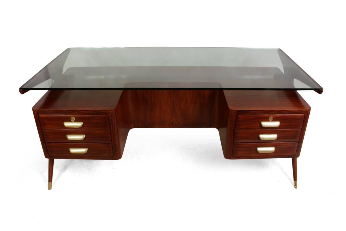Midcentury desk and chair by Vitorrio Dassi
This rosewood executive desk was produced in Italy in the 1950s it has 18mm floating glass top brass handles and feet tips, sculptural rosewood legs, the drawers are lockable but only have one key for the