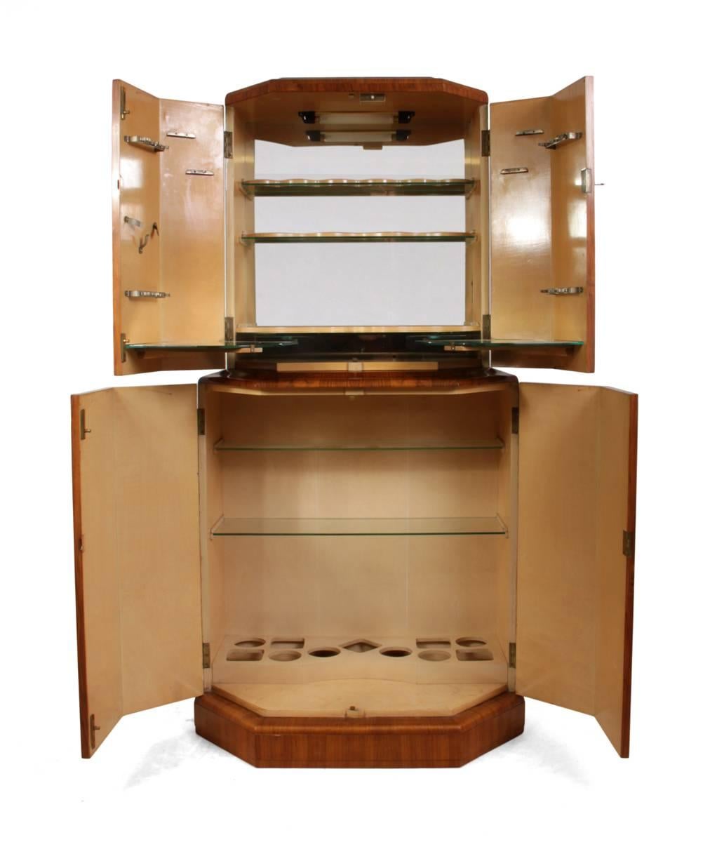 Art Deco cocktail cabinet in walnut, circa 1930
This English cocktail cabinet was produced in the 1930s it is half octagonal shape with lockable doors, the automatic lighting has been re wired, the mirror at the back of the top section has become