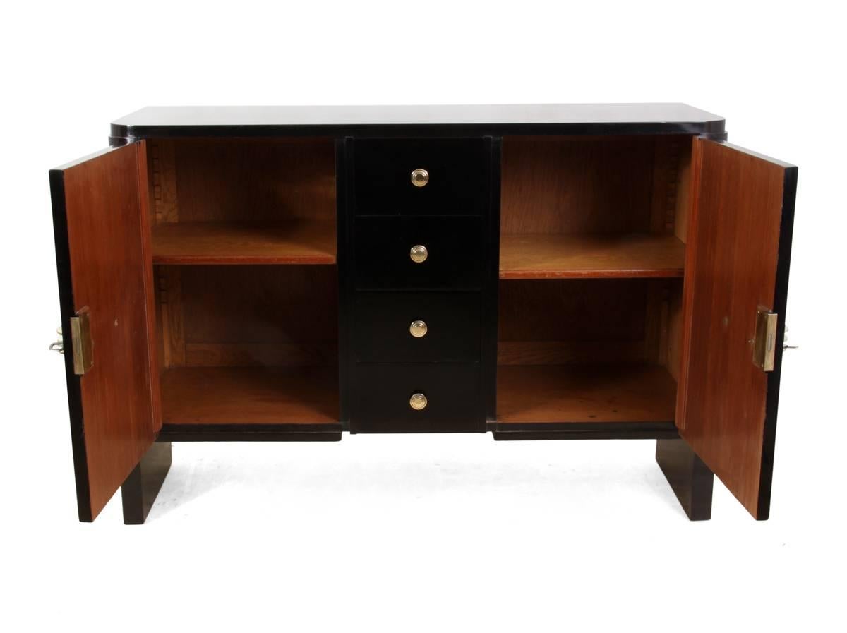 Art Deco sideboard black piano finish, circa 1930
This two door French Art Deco sideboard has four central drawers with two cupboards that have adjustable shelves behind, good quality polished brass handles and both locks with working keys
this