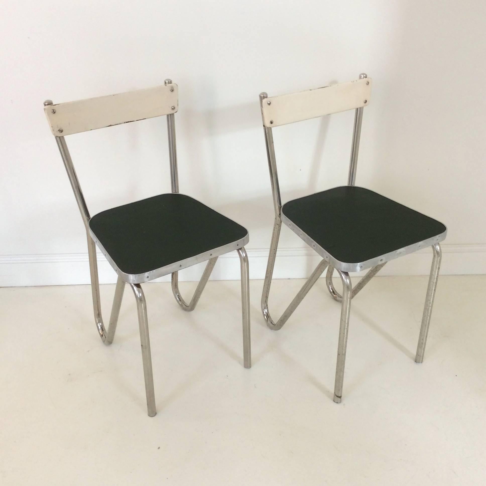 Pair of modernist tubular chairs, circa 1930, France.
Chromed metal, aluminium, ivory painted wood and dark green linoleum.
Dimensions: H: 75 cm, seat height: 45 cm, W 36 cm, D 42 cm.
Some wear consistent with age and use.