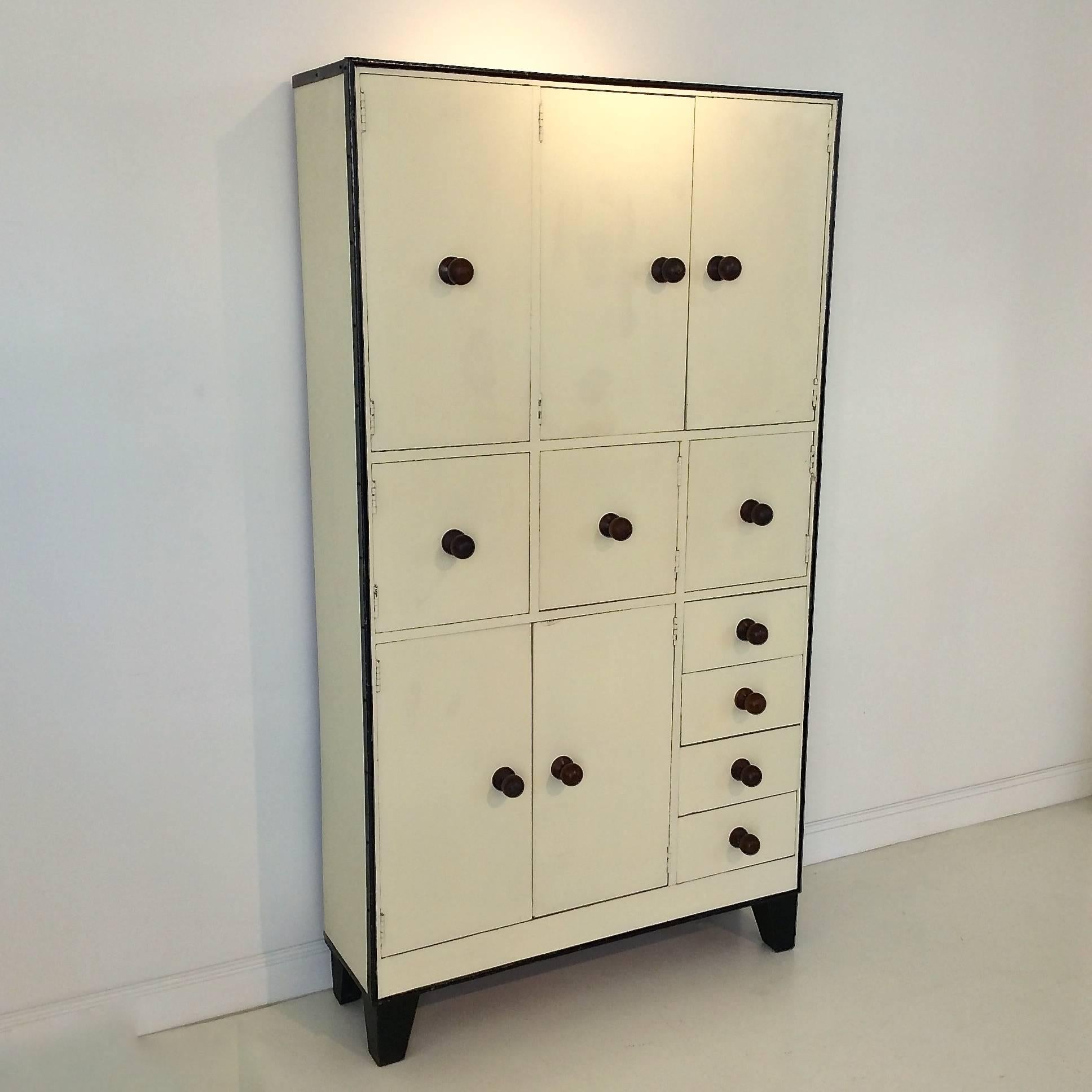 Ivory painted cabinet, probably Dutch, circa 1930.
Eight doors and four drawers.
Painted wood, black metal frame.
Wood handles balls.
Dimensions: H 201 cm, W 111 cm, D 33 cm.
Original condition, wear consistent with age and use.