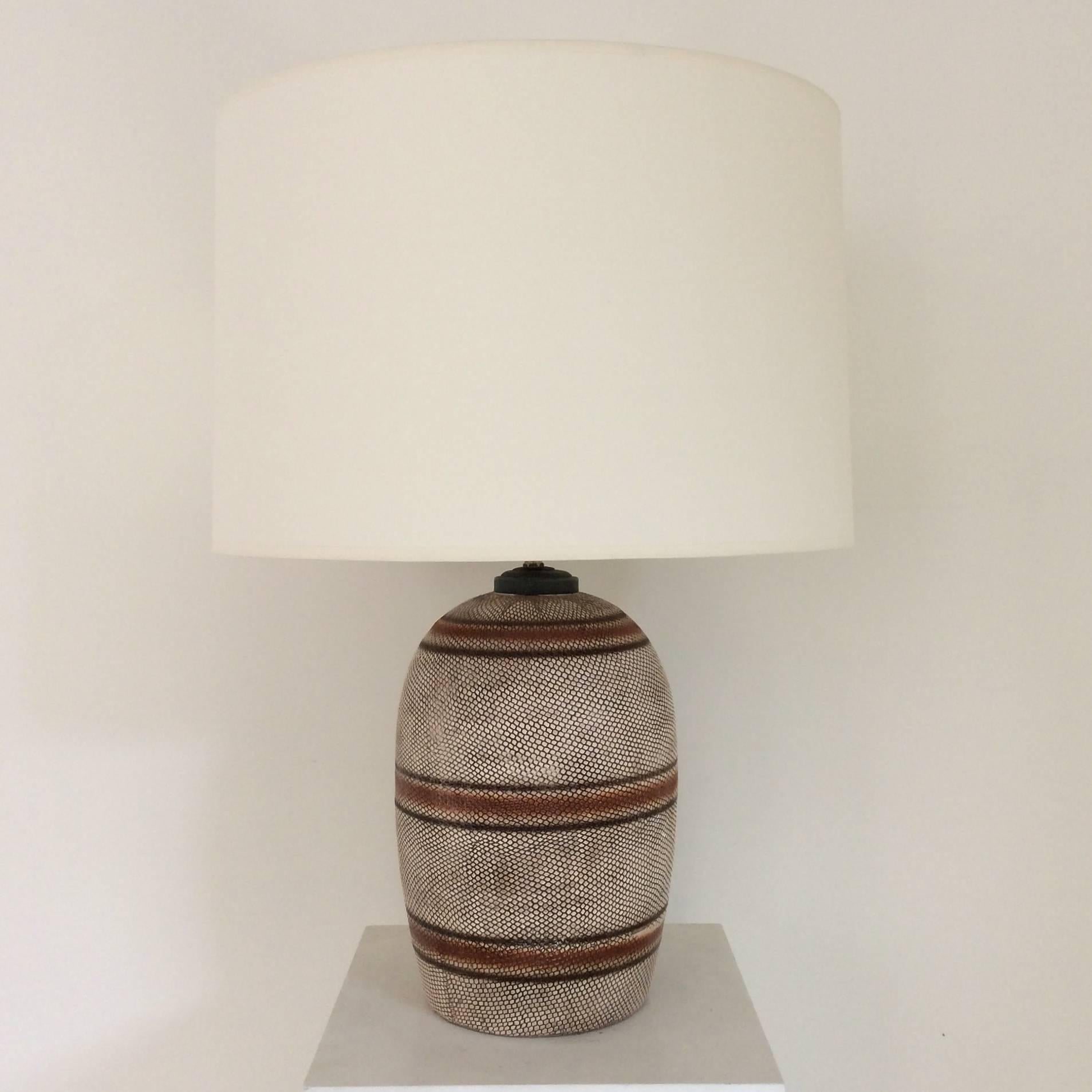 Original ceramic table lamp with snake skin imiation, circa 1950, France.
New ivory fabric shade.
Dimensions: 63 cm H, diameter of the shade, 45 cm.
Rewired, one 60 W E27 bulb .
Good vintage condition.
We ship worldwide.
      