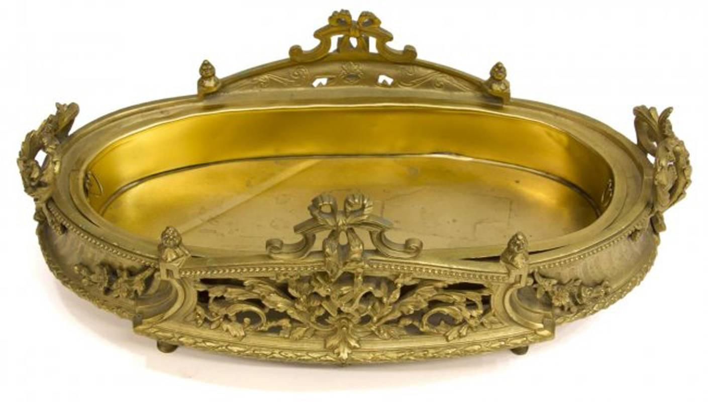 Beautiful 19th century French Louis XV style oval ormolu centerpiece centered by intricate fretwork panel flanked by two scrolling foliage handles on four bronze feet with brass liner.

The measurements are height 6 inches x width 16.5 inches x